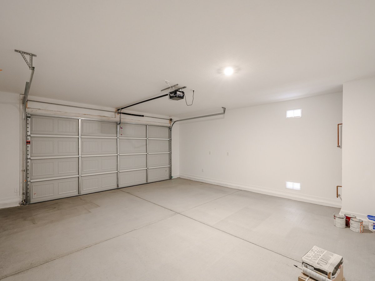 A room with a large white wall and a metal object on the ceiling.