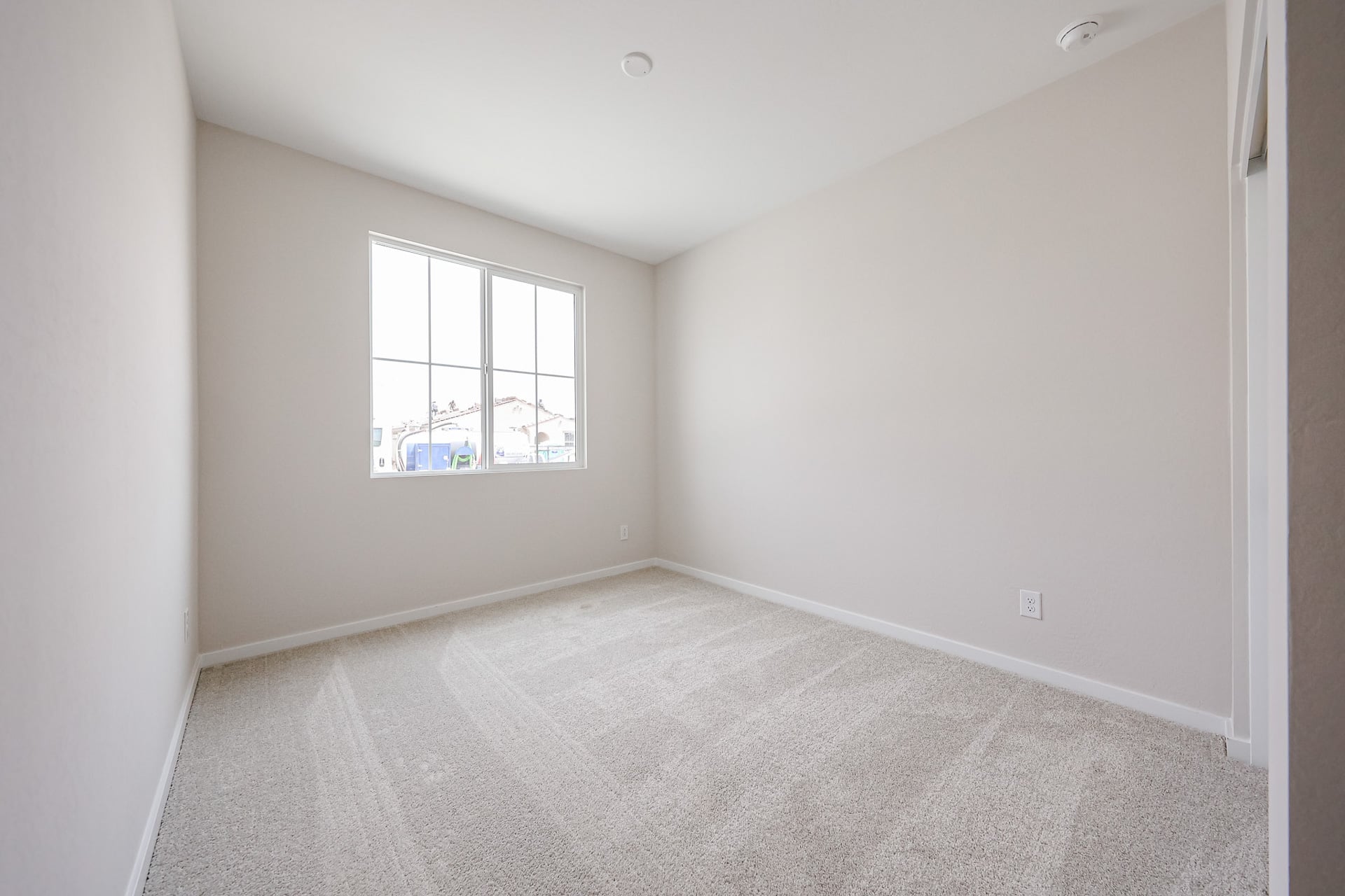 A room with a carpet and a window.