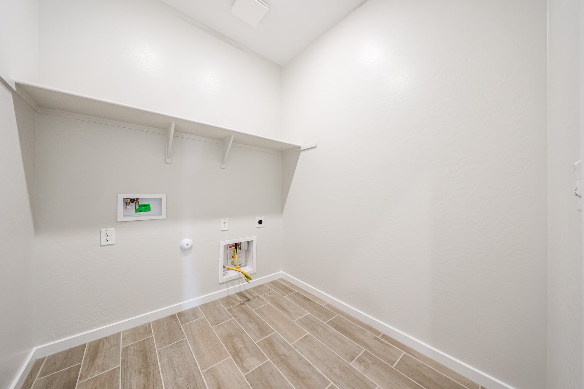 A room with a tile floor and a white wall with a sign on it.