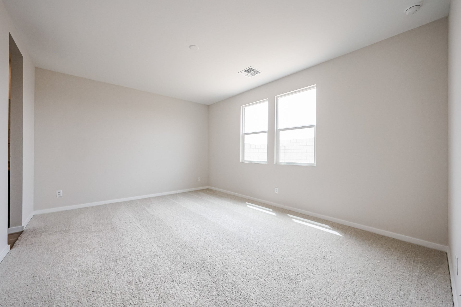 A room with a carpet and windows.