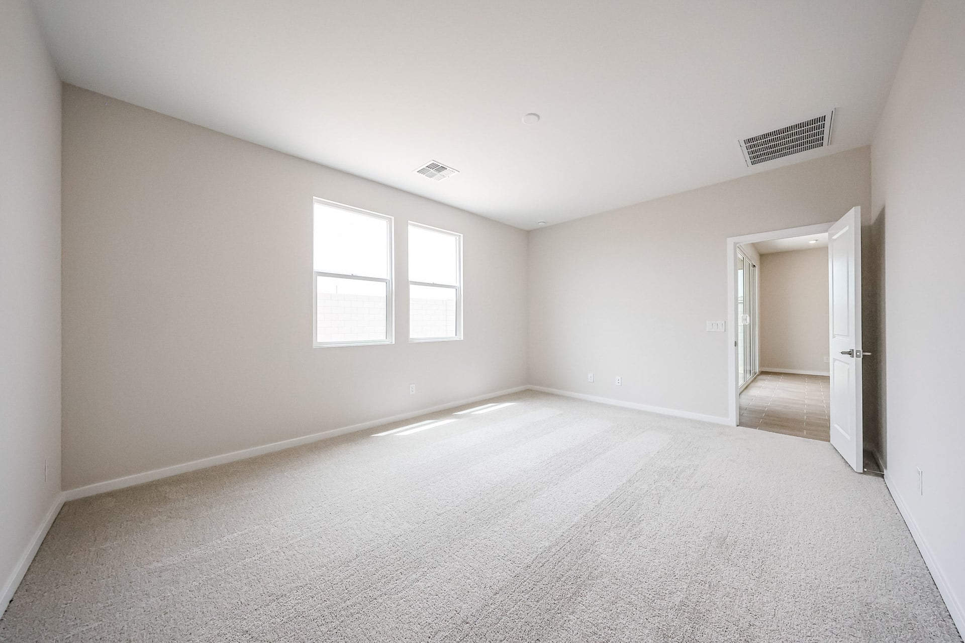 A room with a carpet and a door.