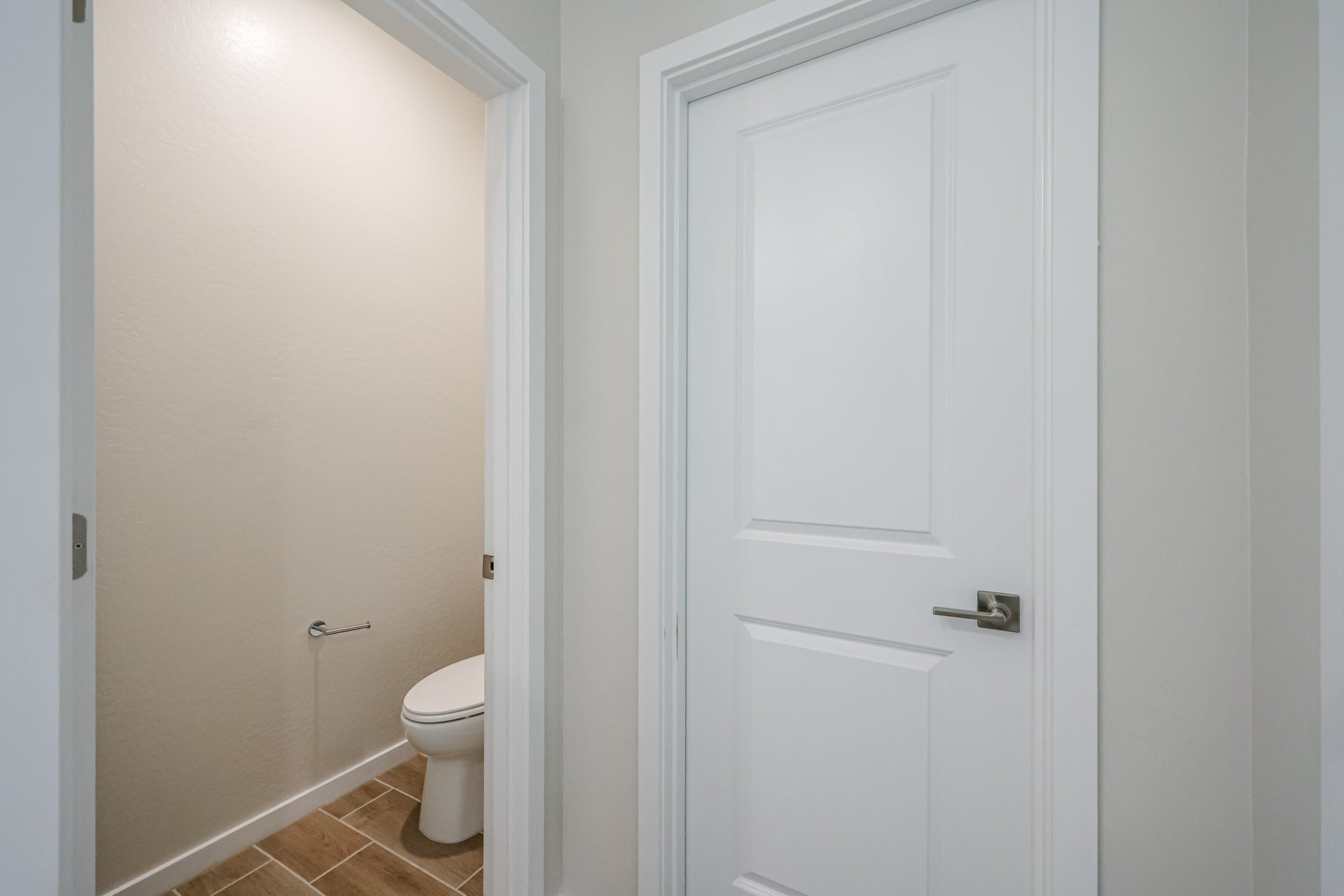 A white door next to a toilet.
