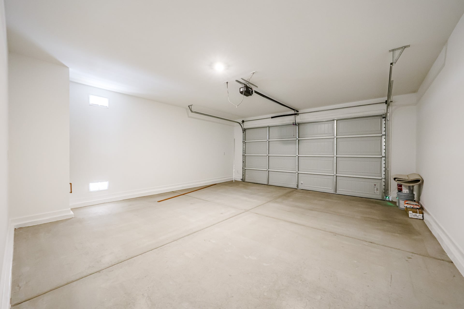 A room with a white wall and a metal gate.