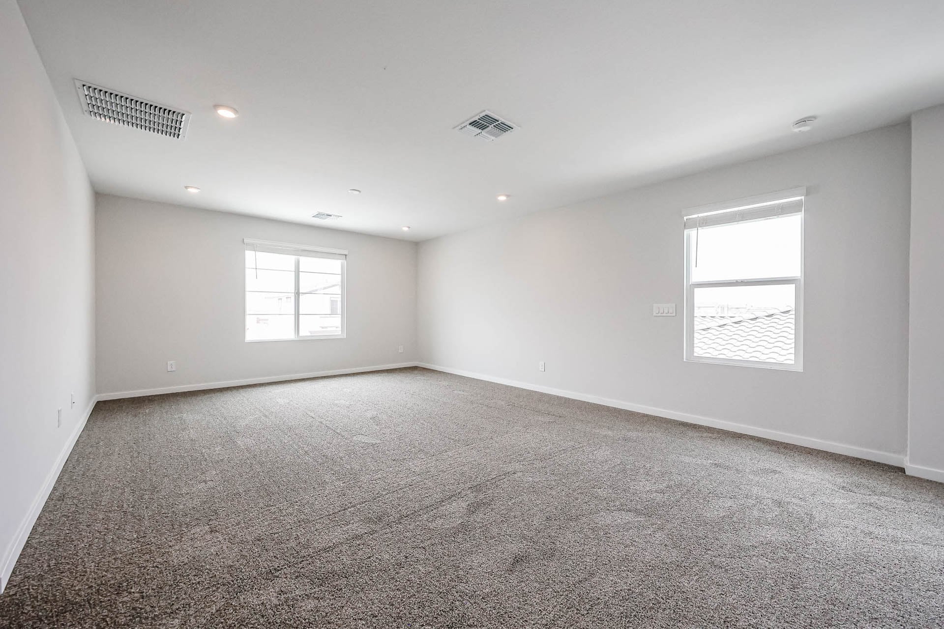 A room with a carpet and windows.