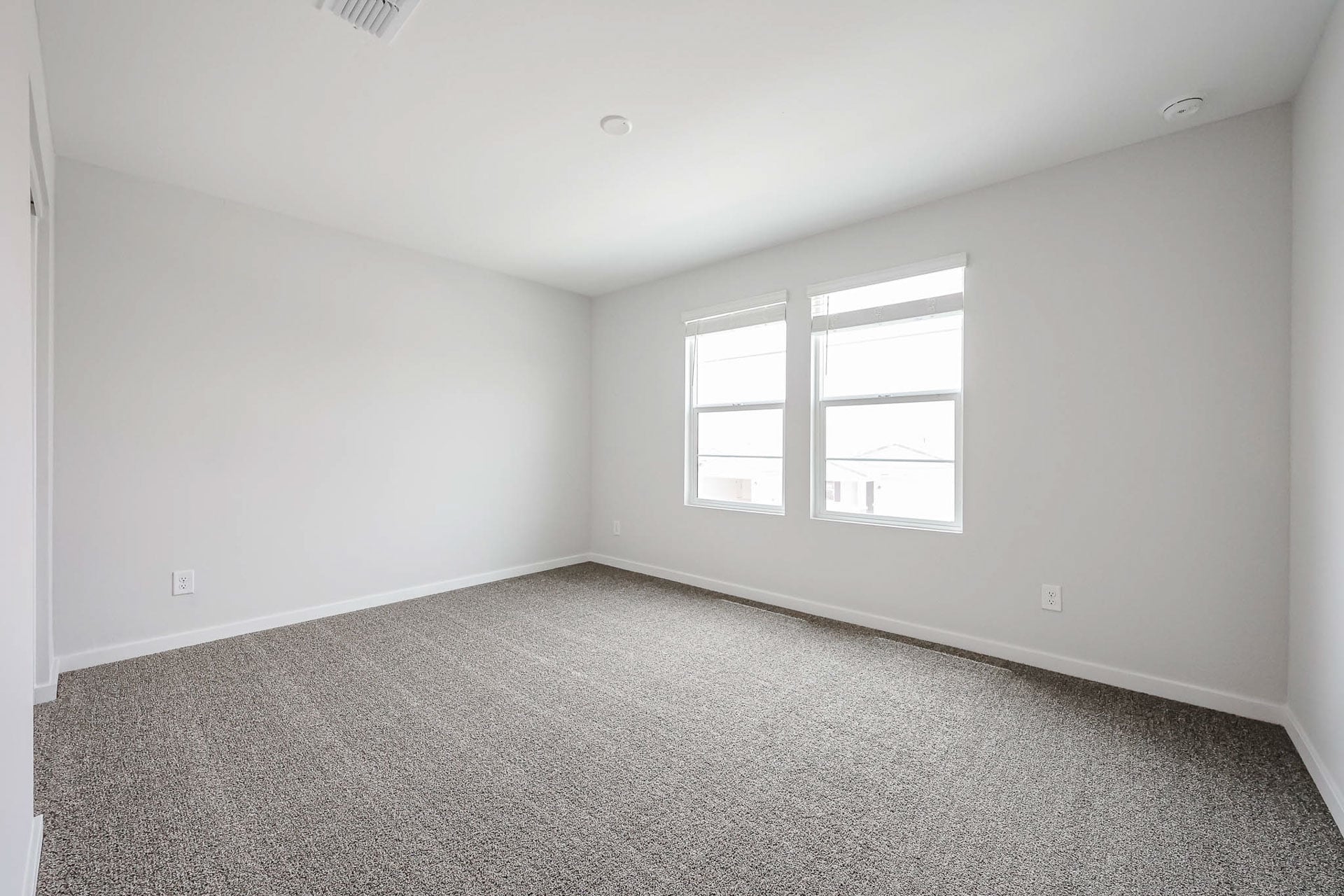 A room with a carpet and windows.