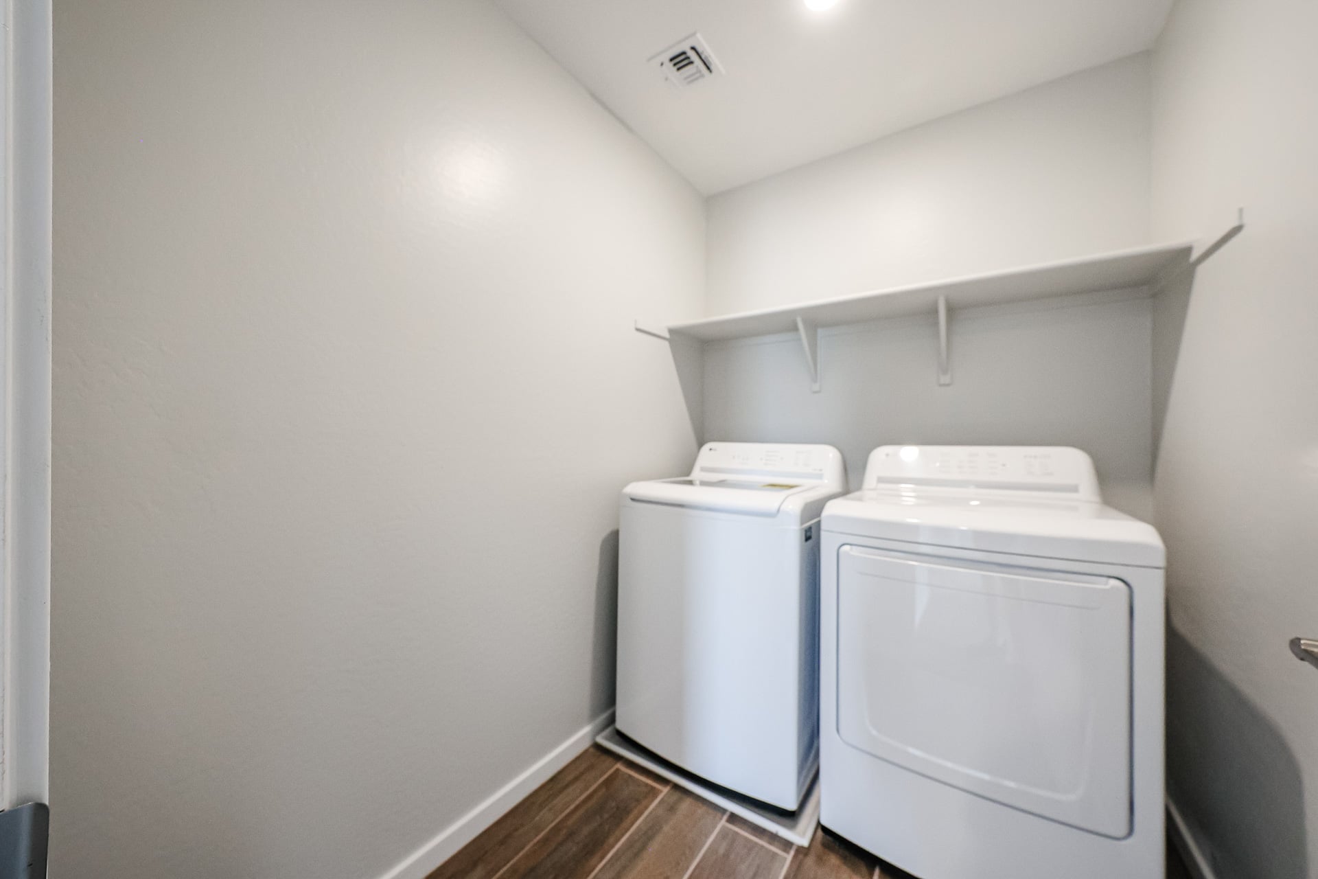 A white refrigerator and a dryer in a room.