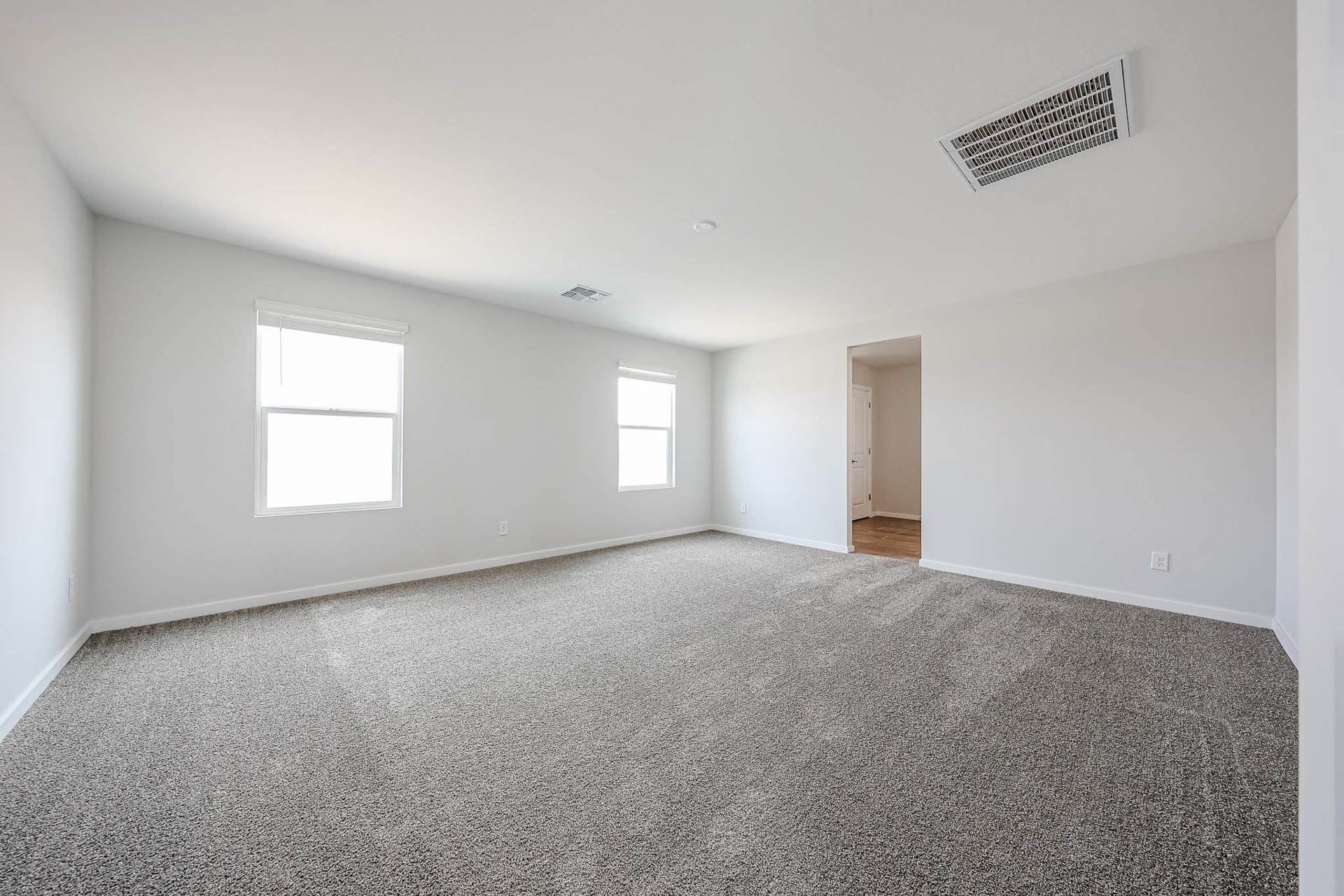 A room with a carpet and windows.