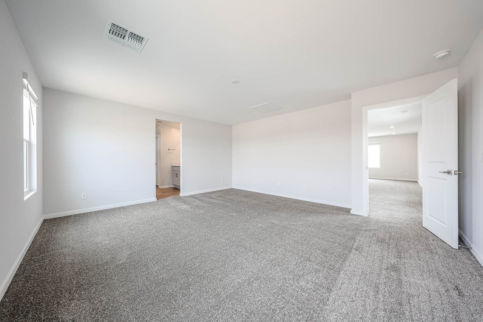 A long hallway with white doors.