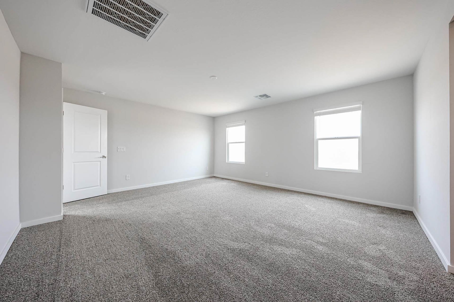 A room with a carpet and windows.