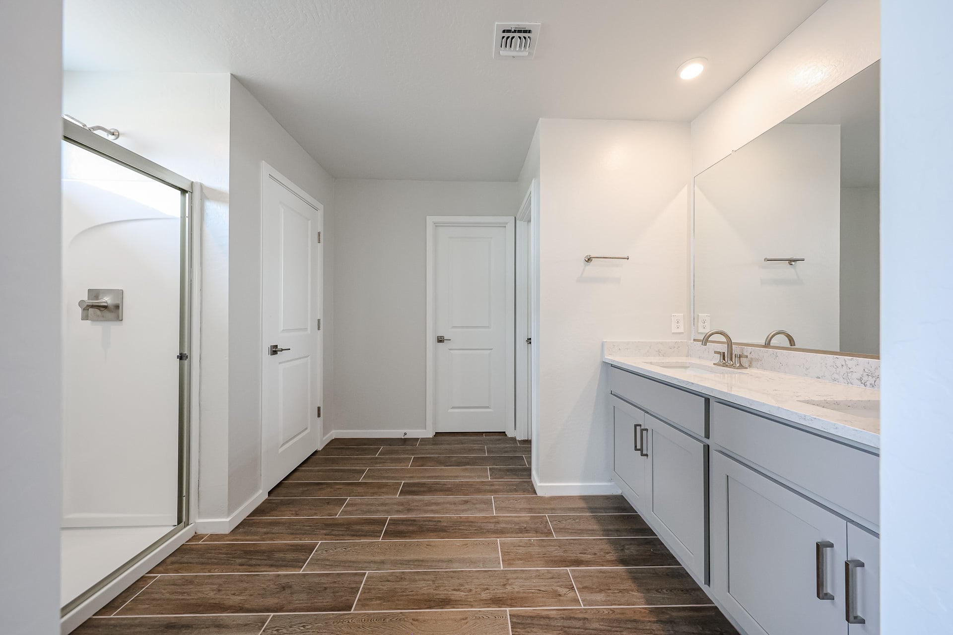 A bathroom with white cabinets.