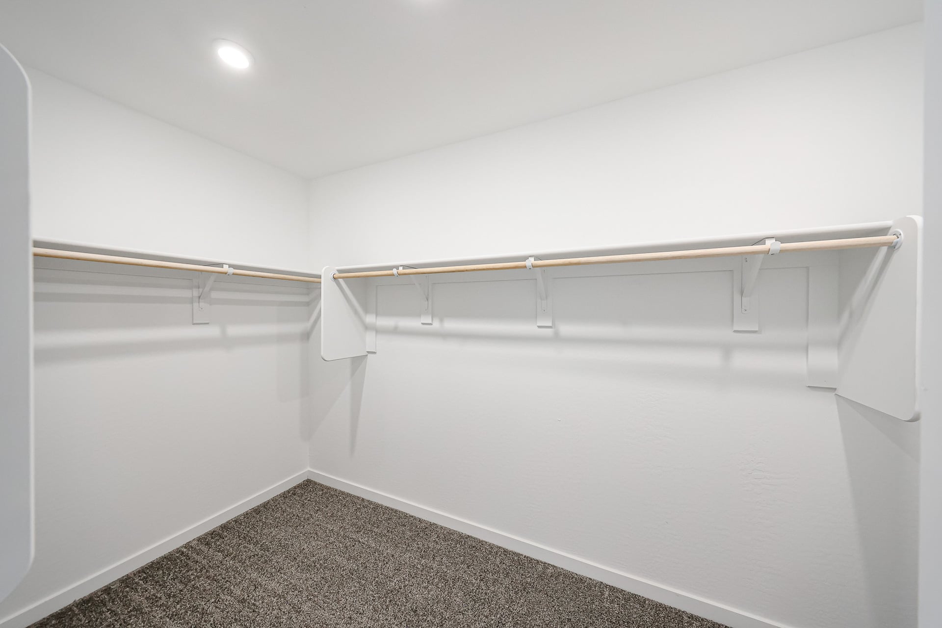 A white wall with a metal bar.