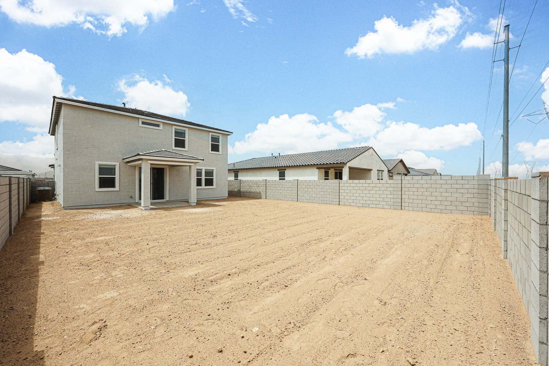 A dirt road with a building on the side.
