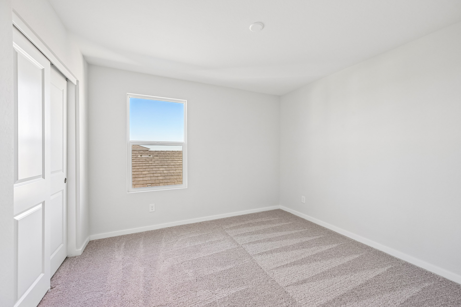 A room with a window and a rug.