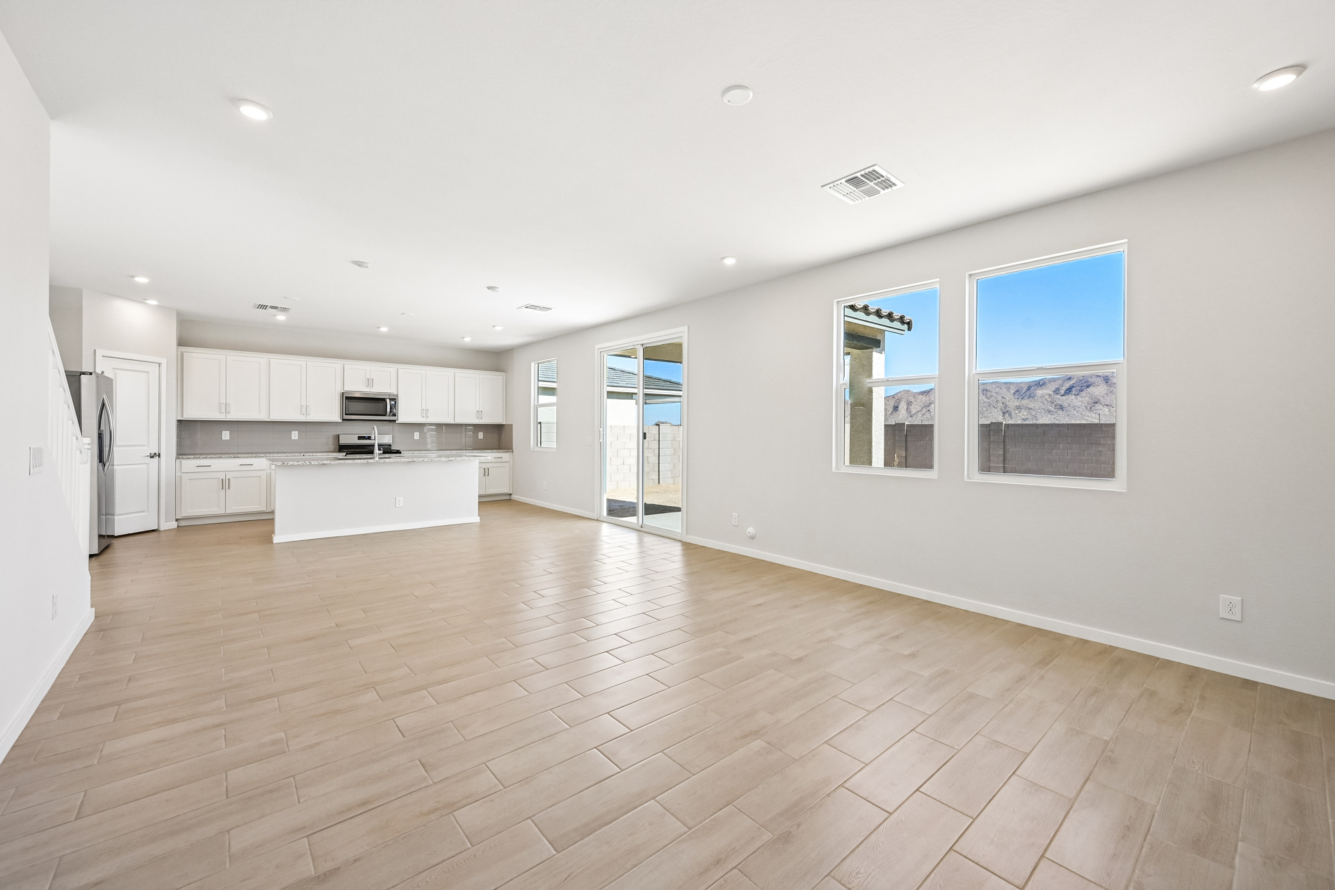 A large empty room with white cabinets.