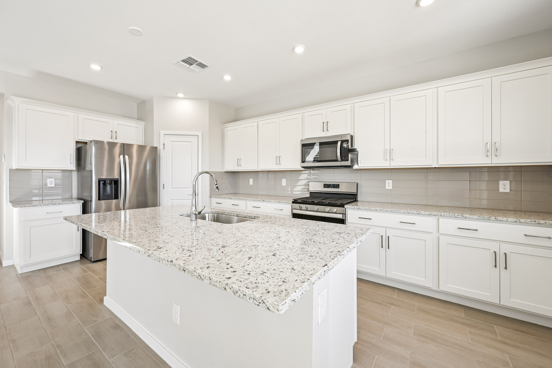 A kitchen with white cabinets.