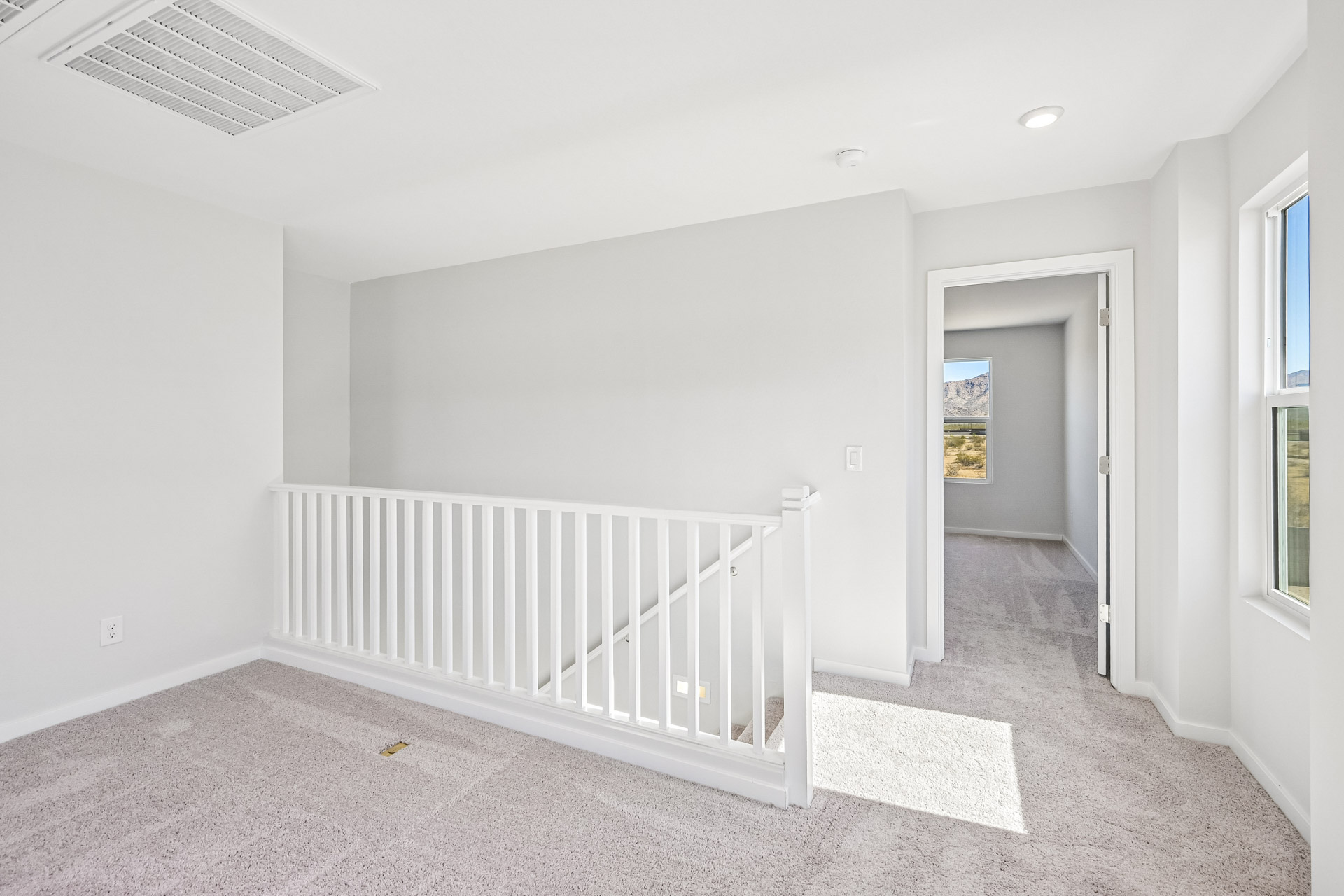 A white room with a white railing.