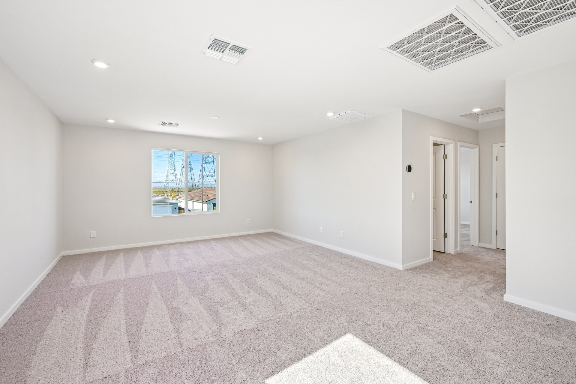 A large empty room with a carpet.