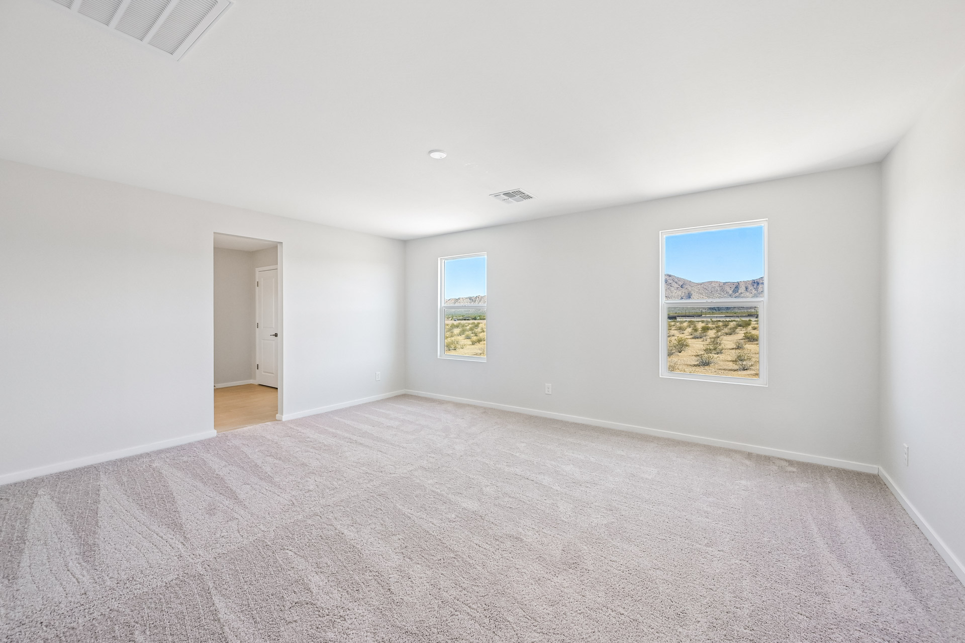 A room with a carpet and a door.