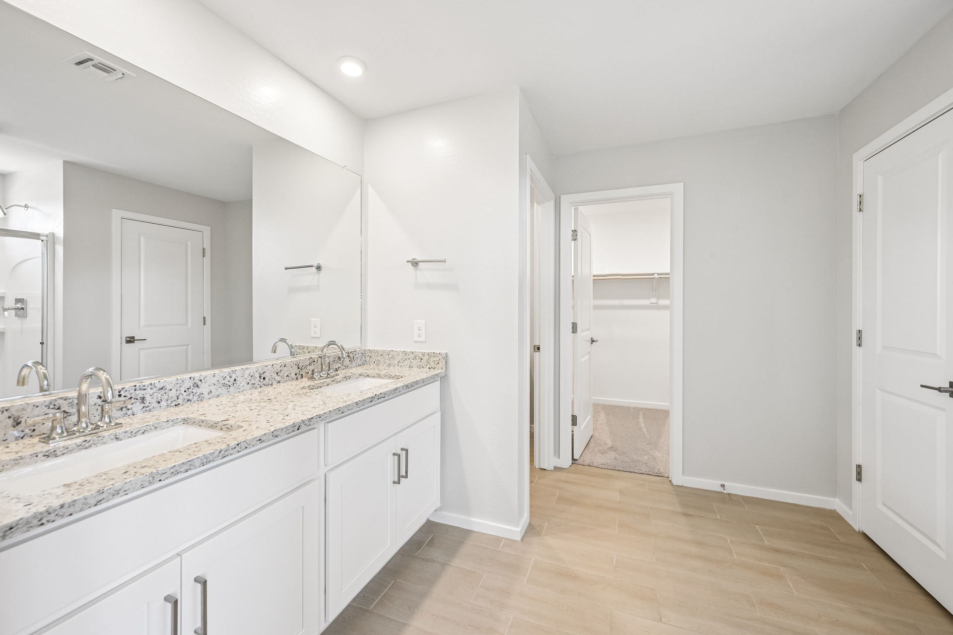 A bathroom with white cabinets.