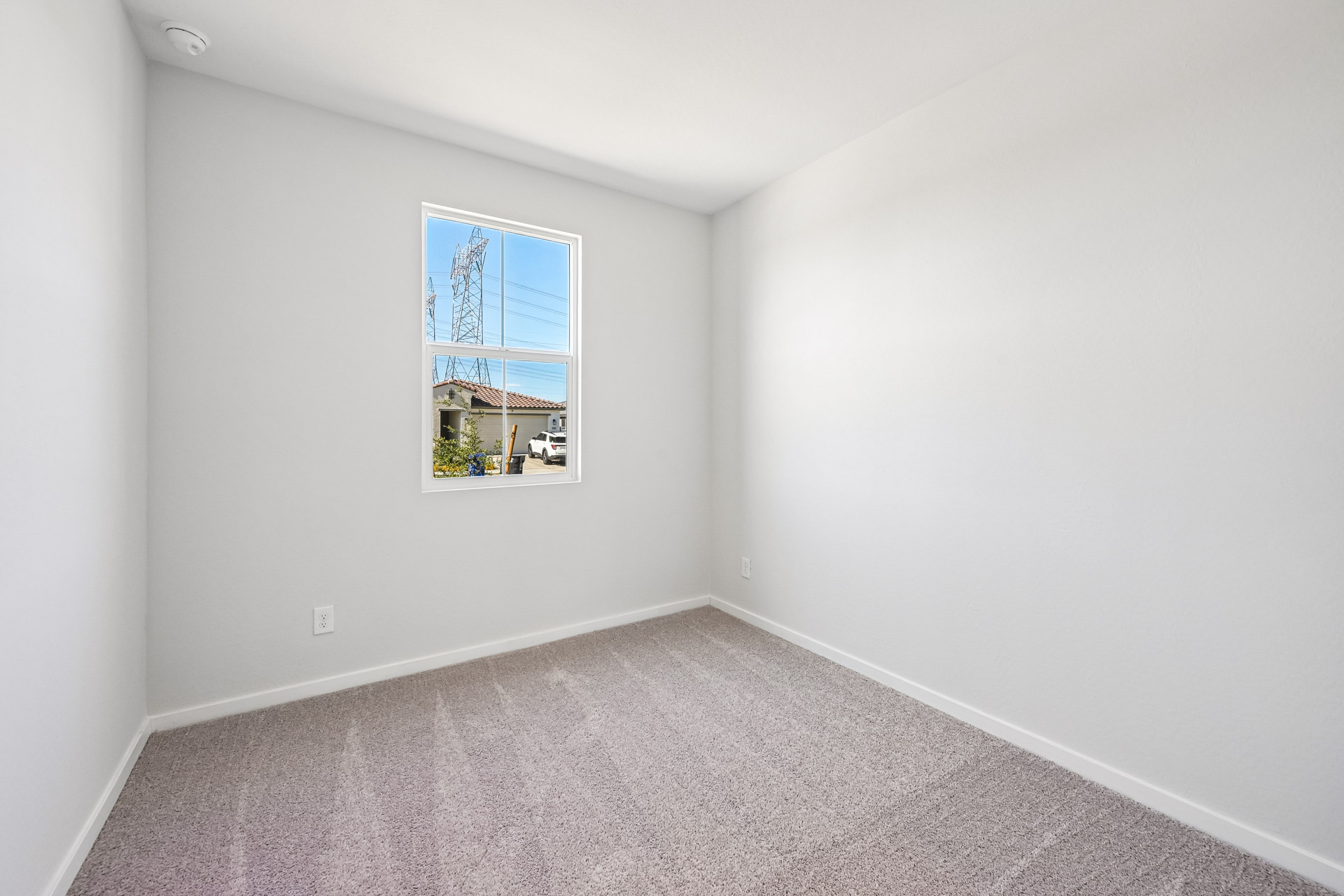 A room with a window and a rug.