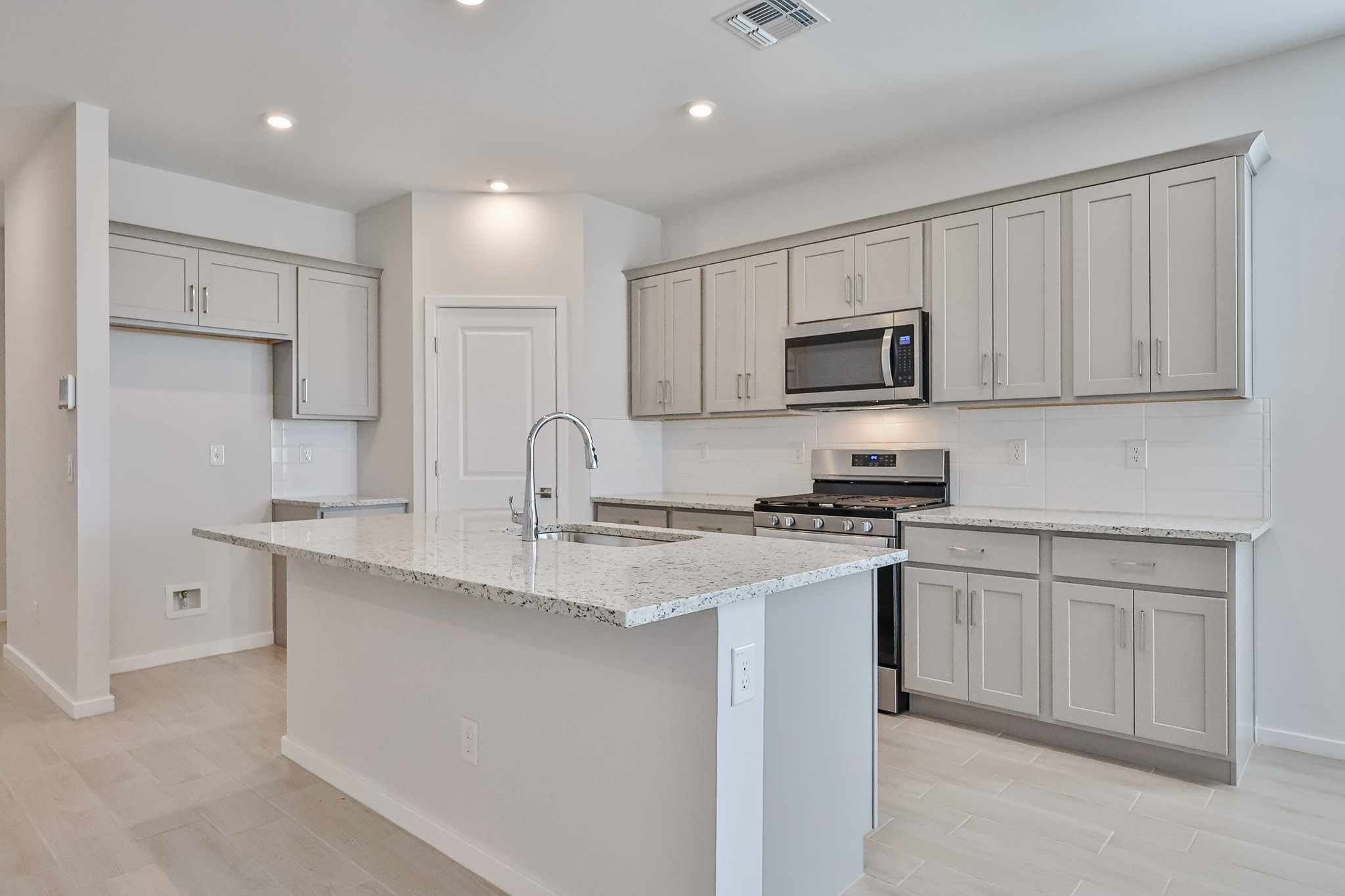 A kitchen with white cabinets.