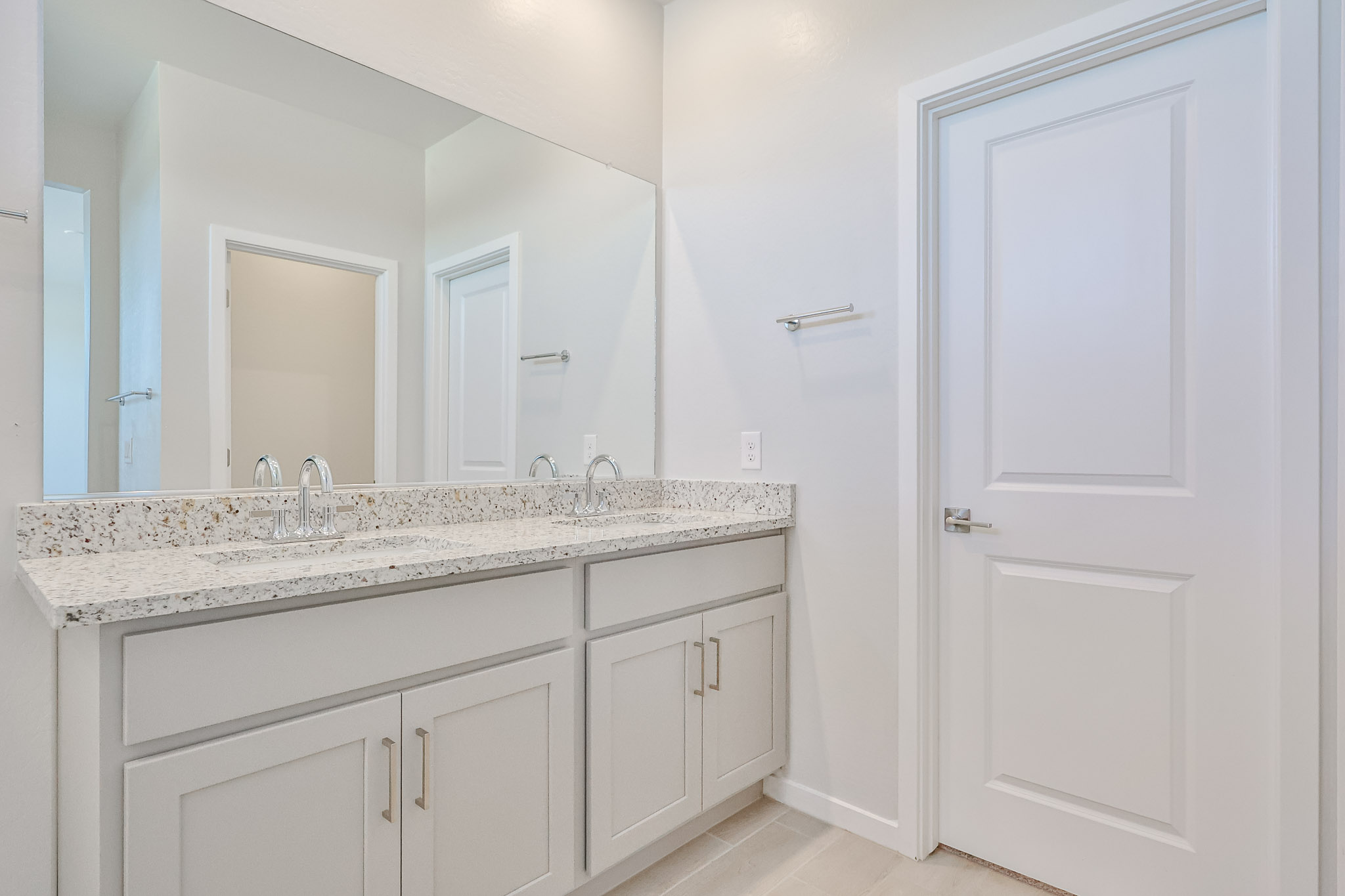 A bathroom with white cabinets.