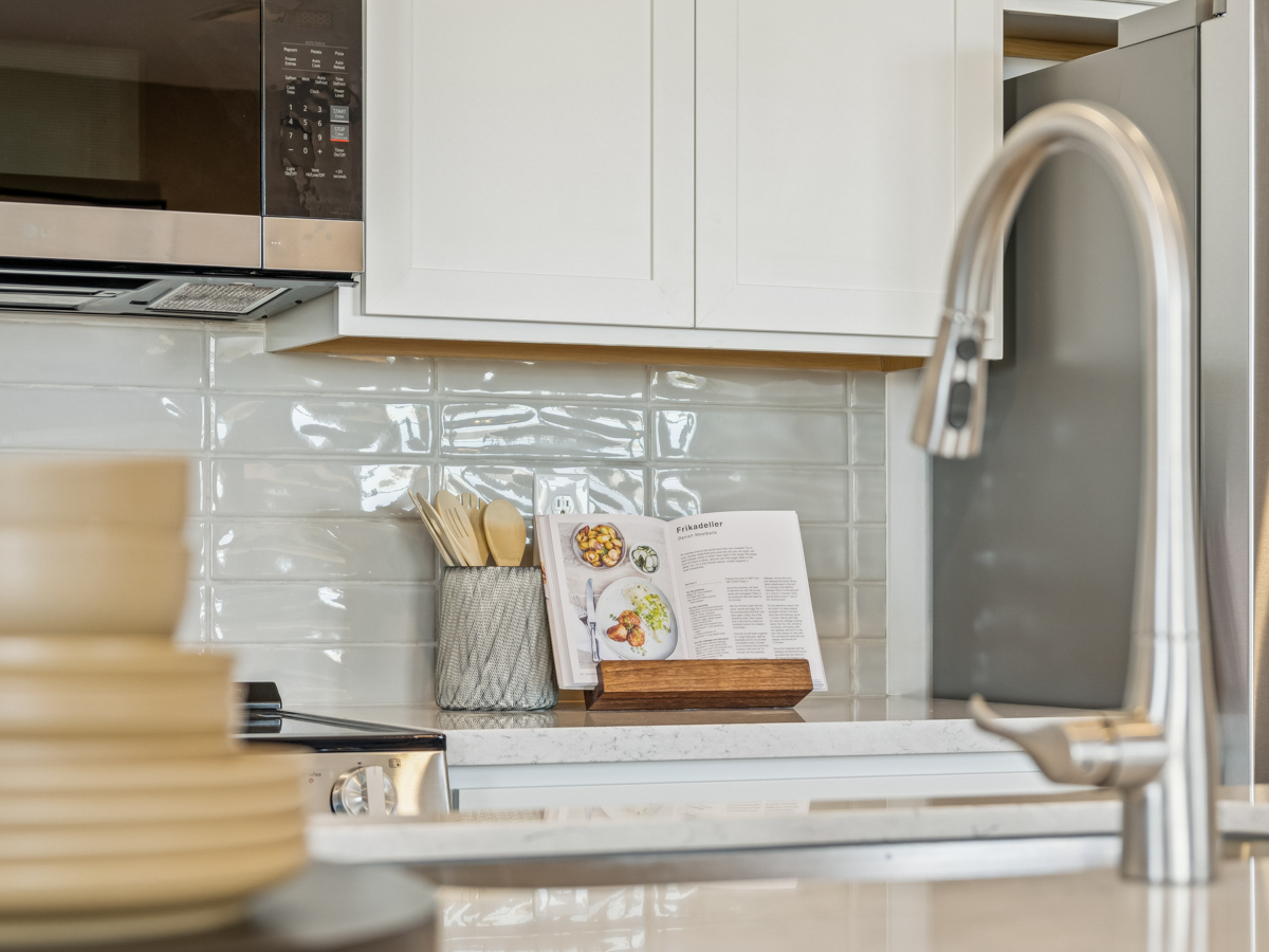 A kitchen with a microwave oven and a book on the counter.