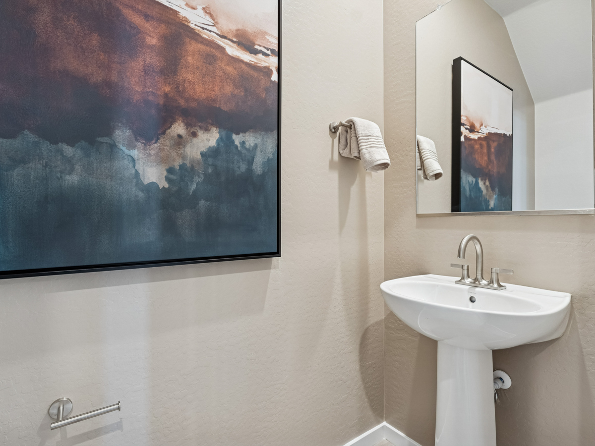 A bathroom with a large painting on the wall.