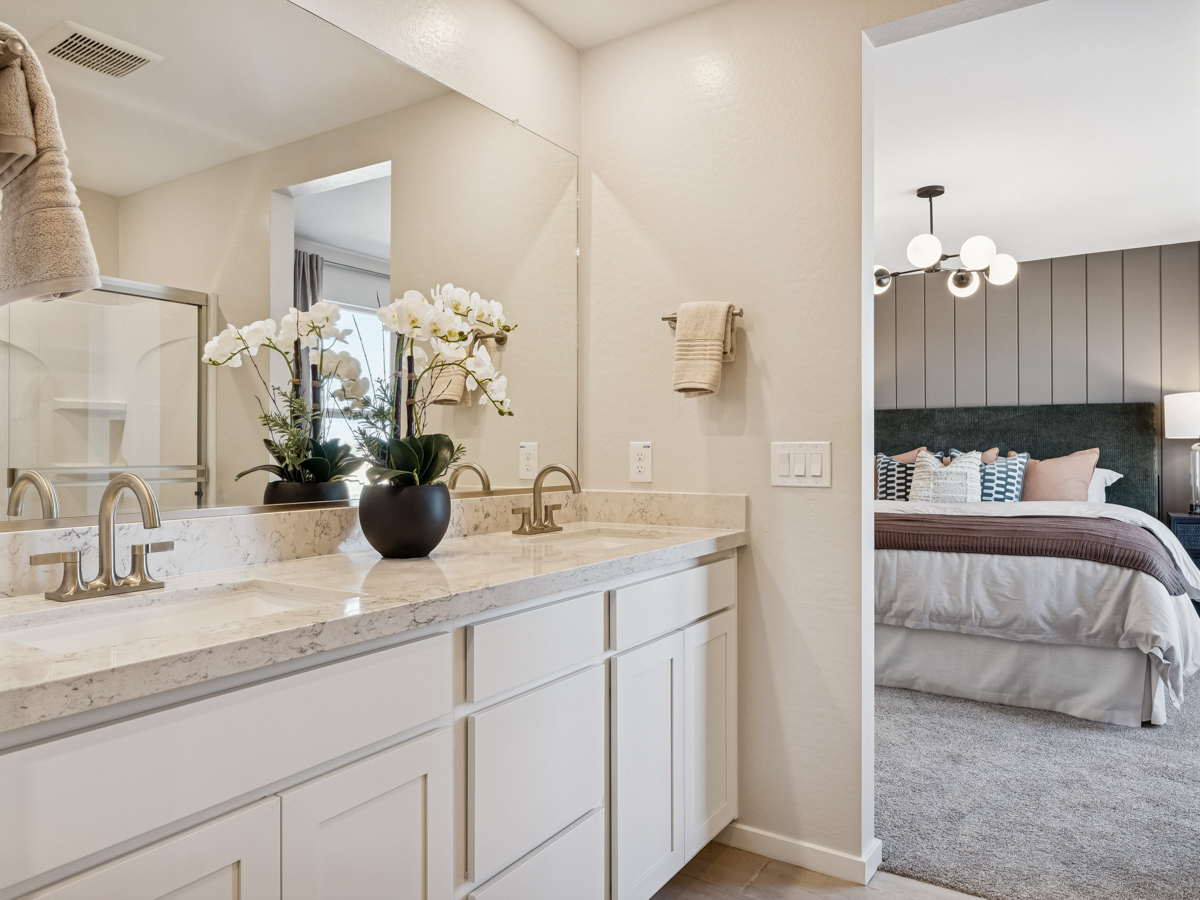 A bathroom with a tub sink and a bed.