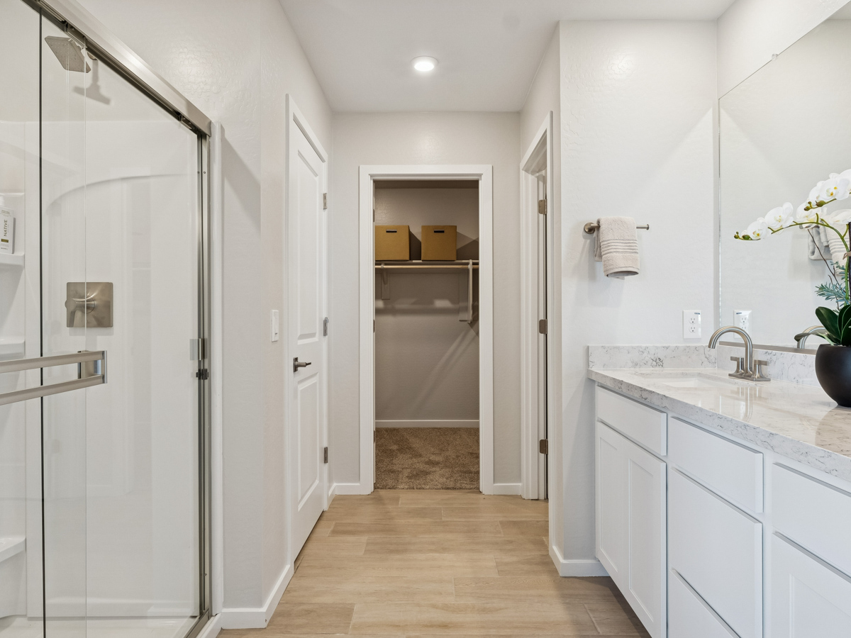 A bathroom with white cabinets.