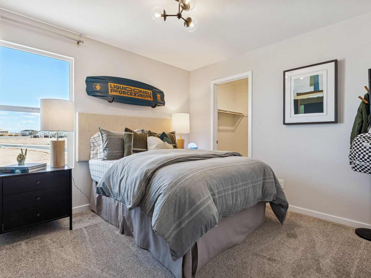 A bedroom with a bed and a desk.