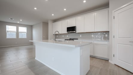 A kitchen with white cabinets.