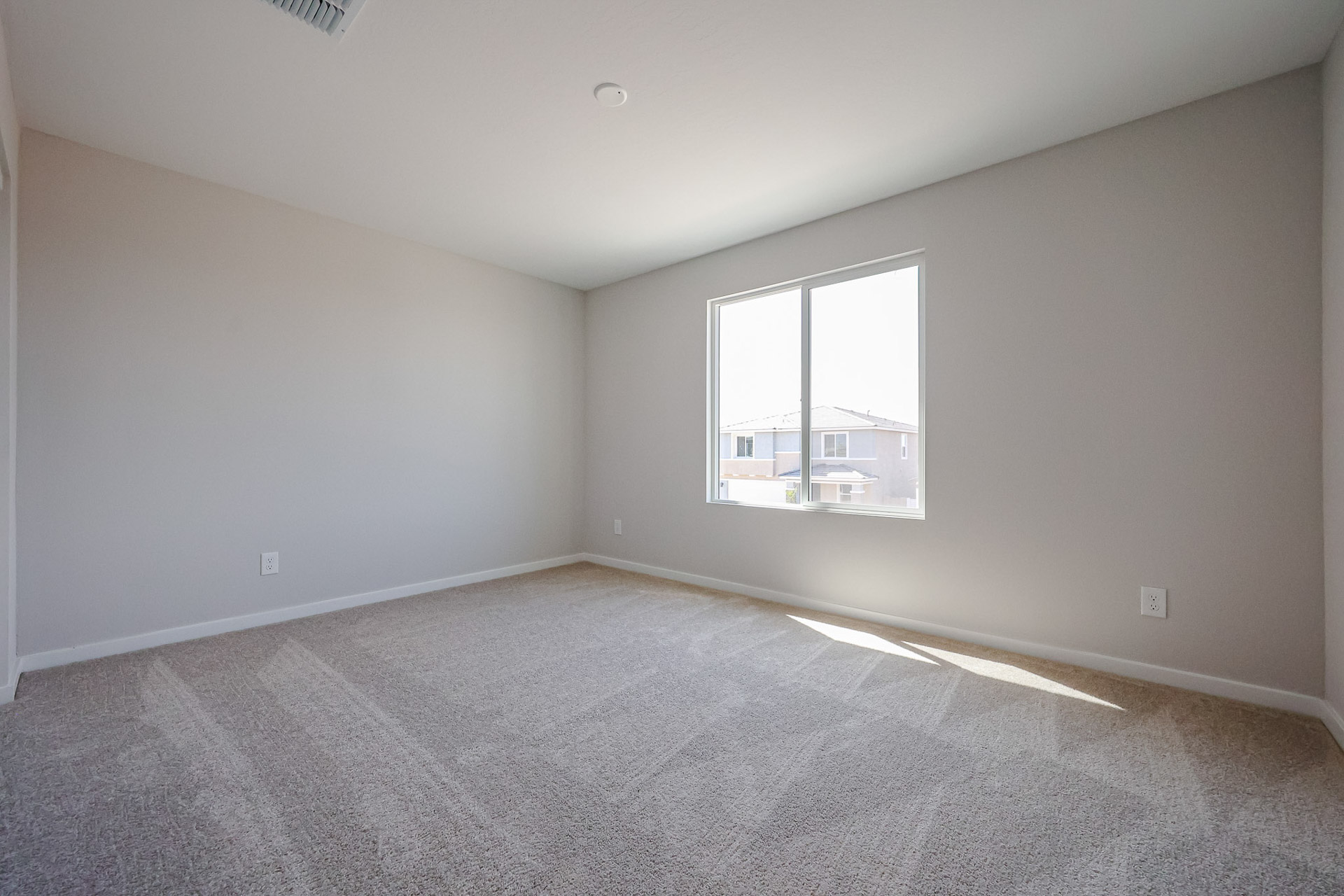 A room with a window and carpet.