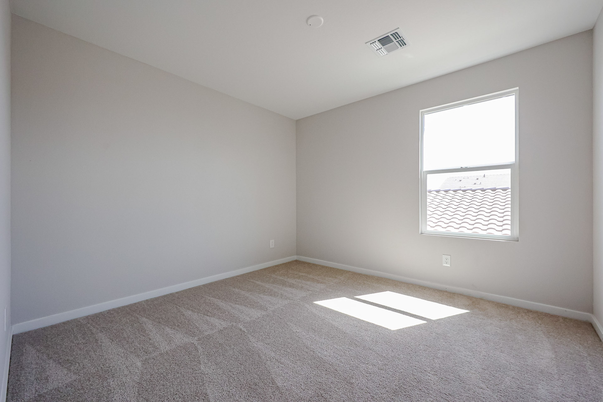 A room with a carpet and windows.