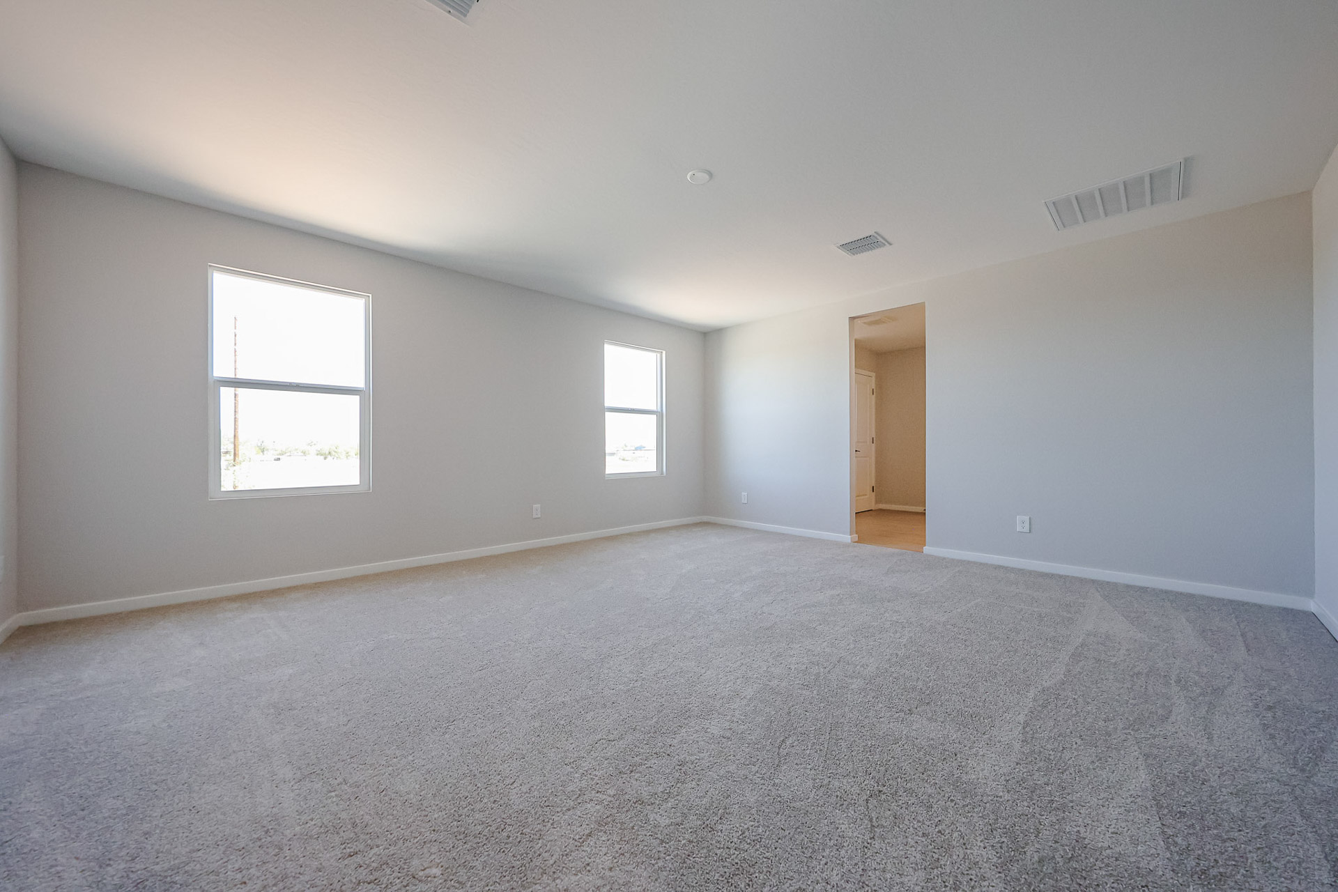 A room with a carpet and windows.