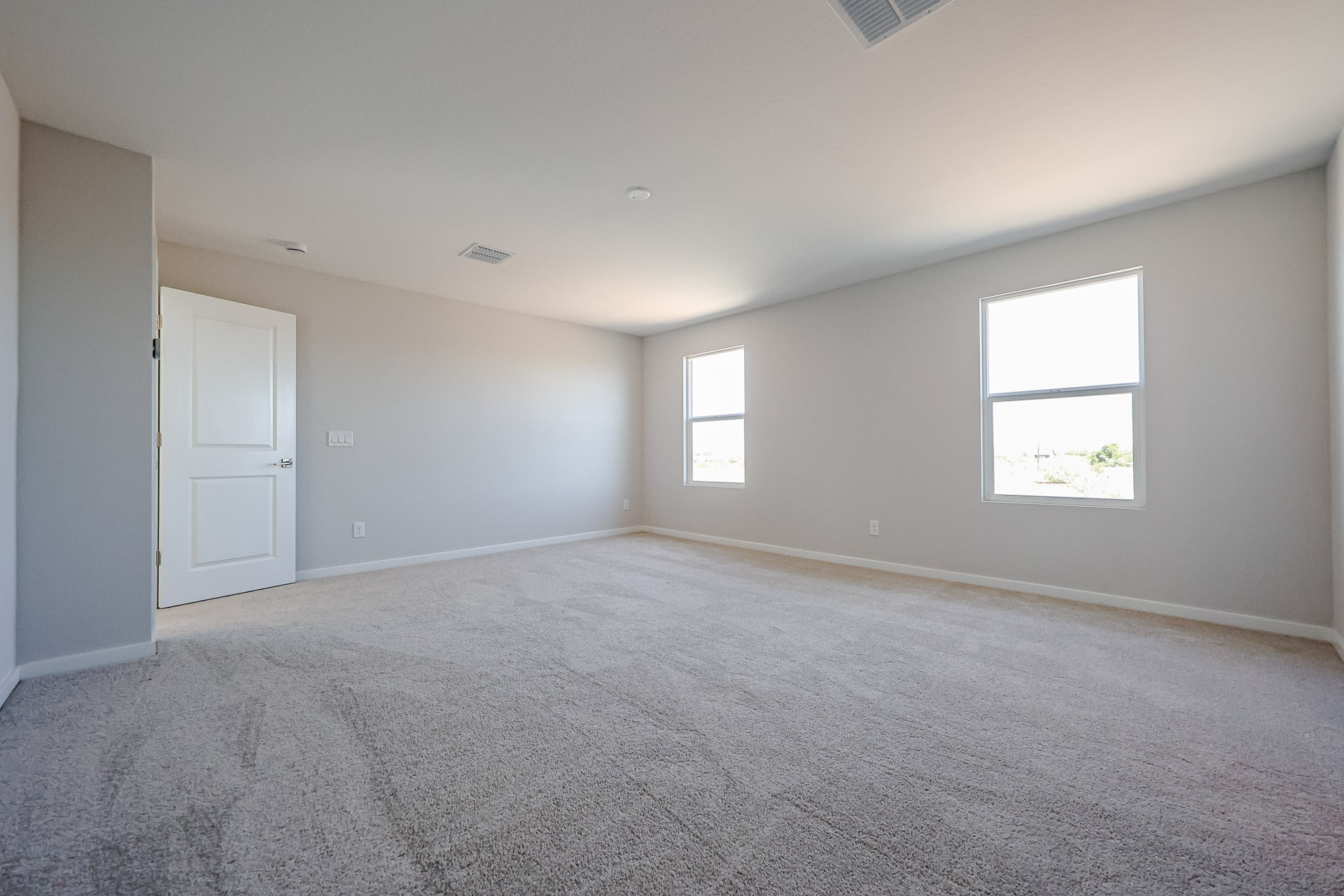 A room with a carpet and windows.