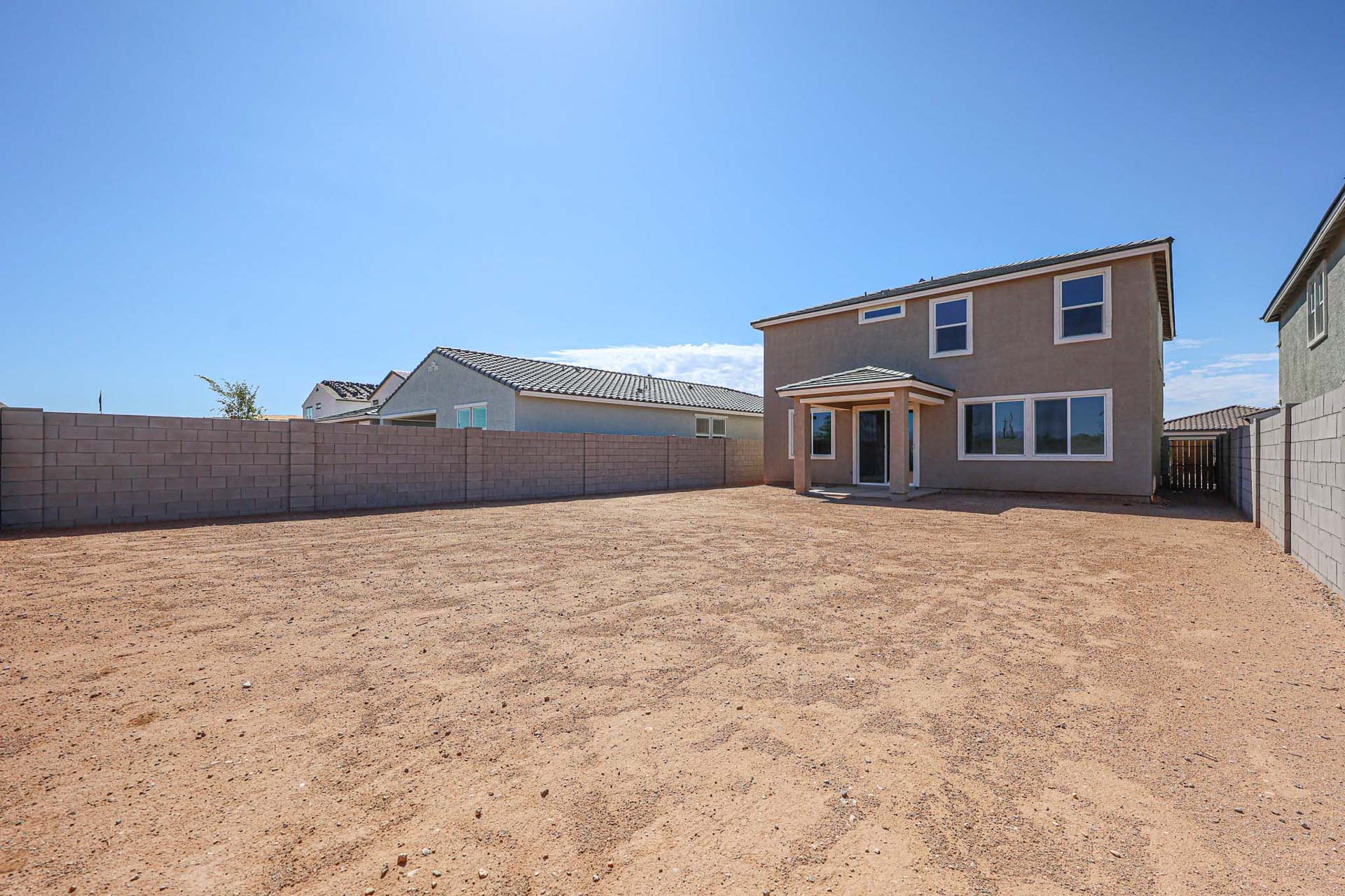 A dirt field with buildings in the background.