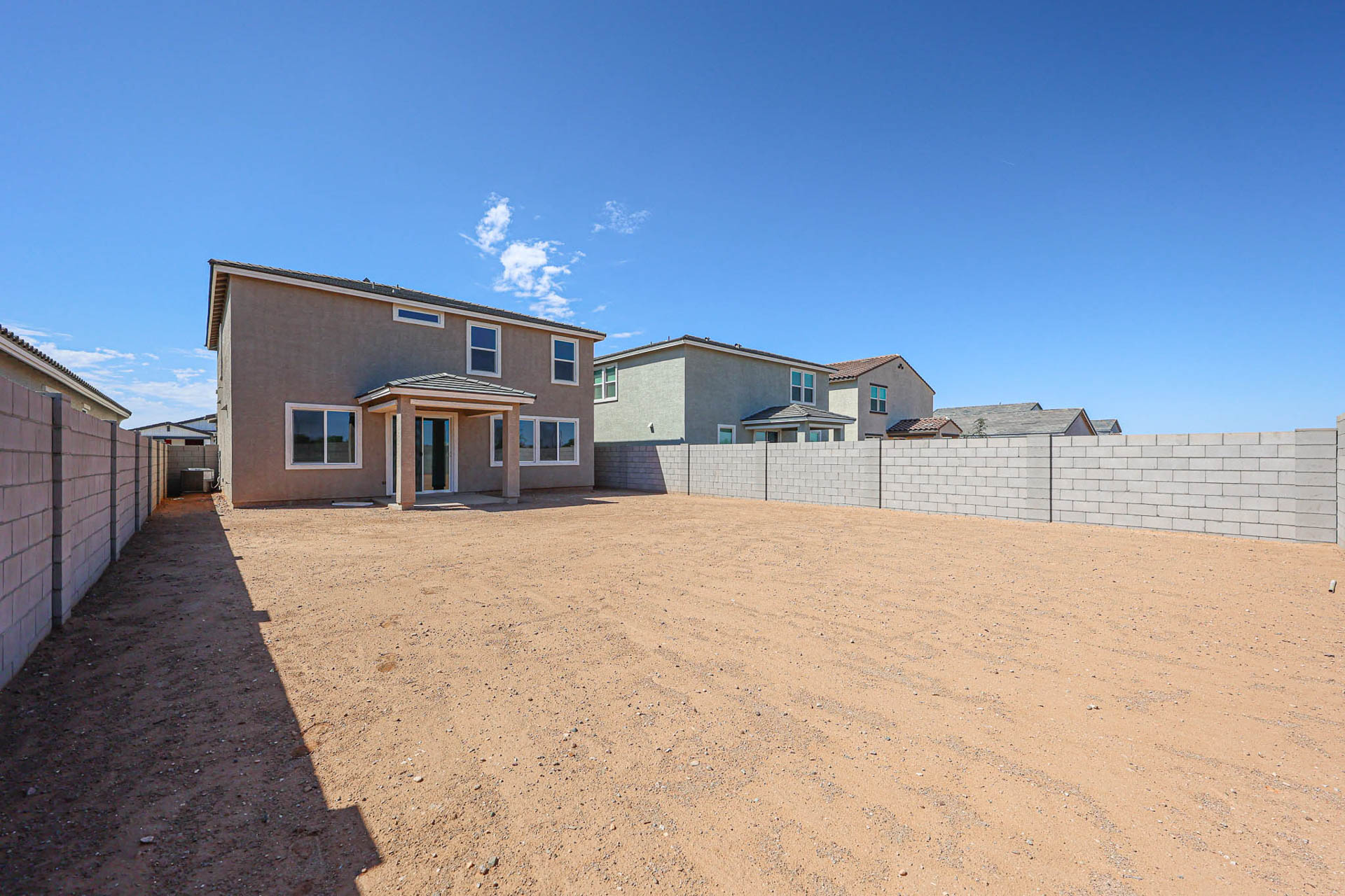 A dirt road with buildings on the side.