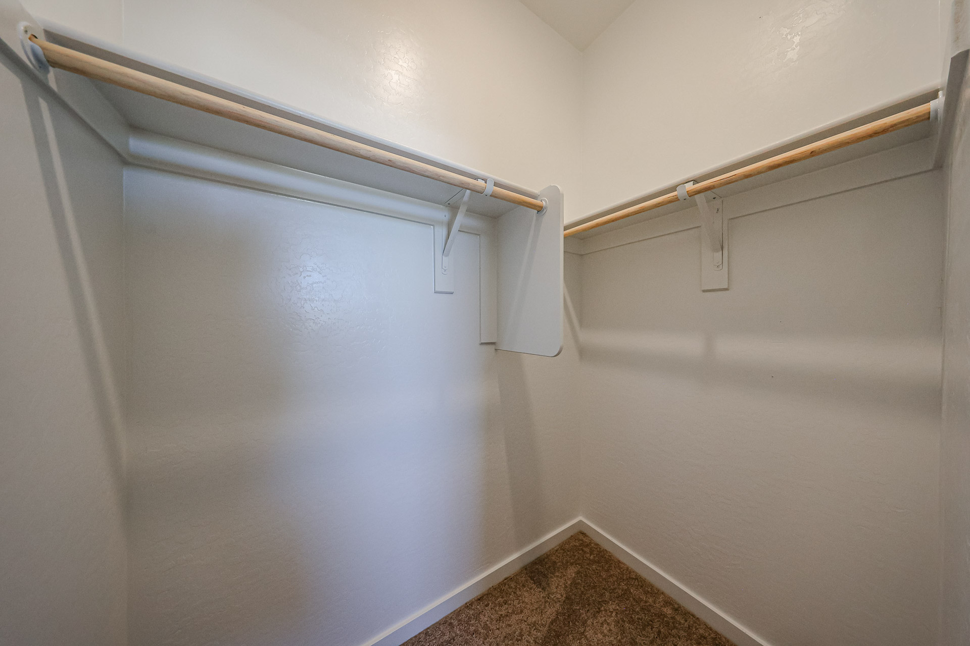 A white wall with a metal bar.