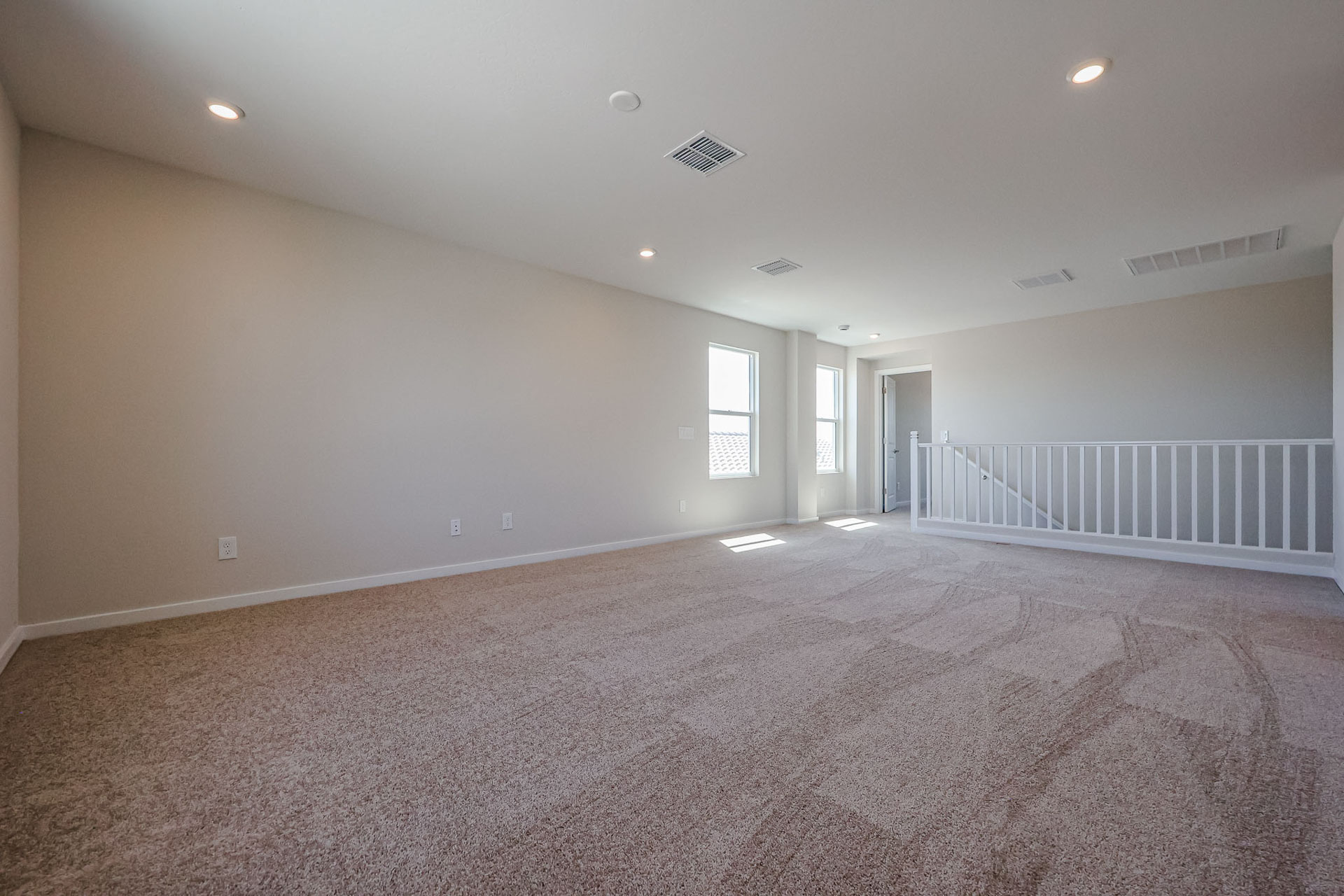 A room with a carpet and a railing.