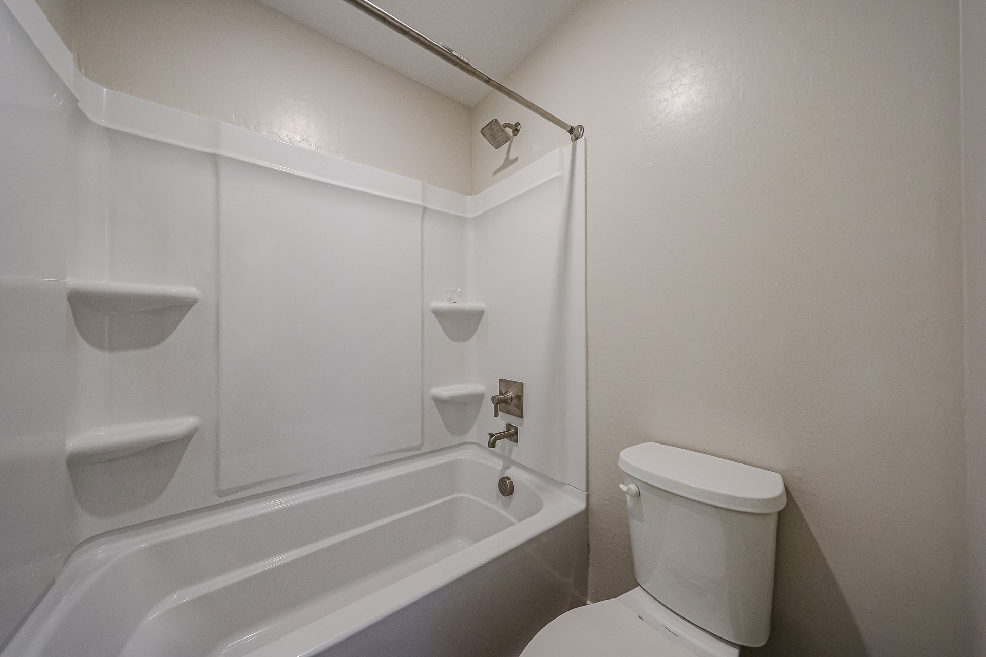 A bathroom with a toilet and bathtub.