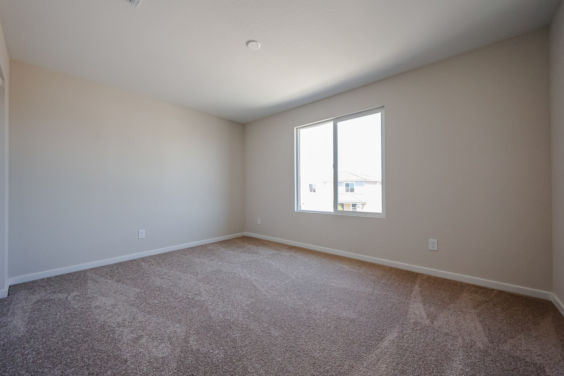 A room with a window and carpet.
