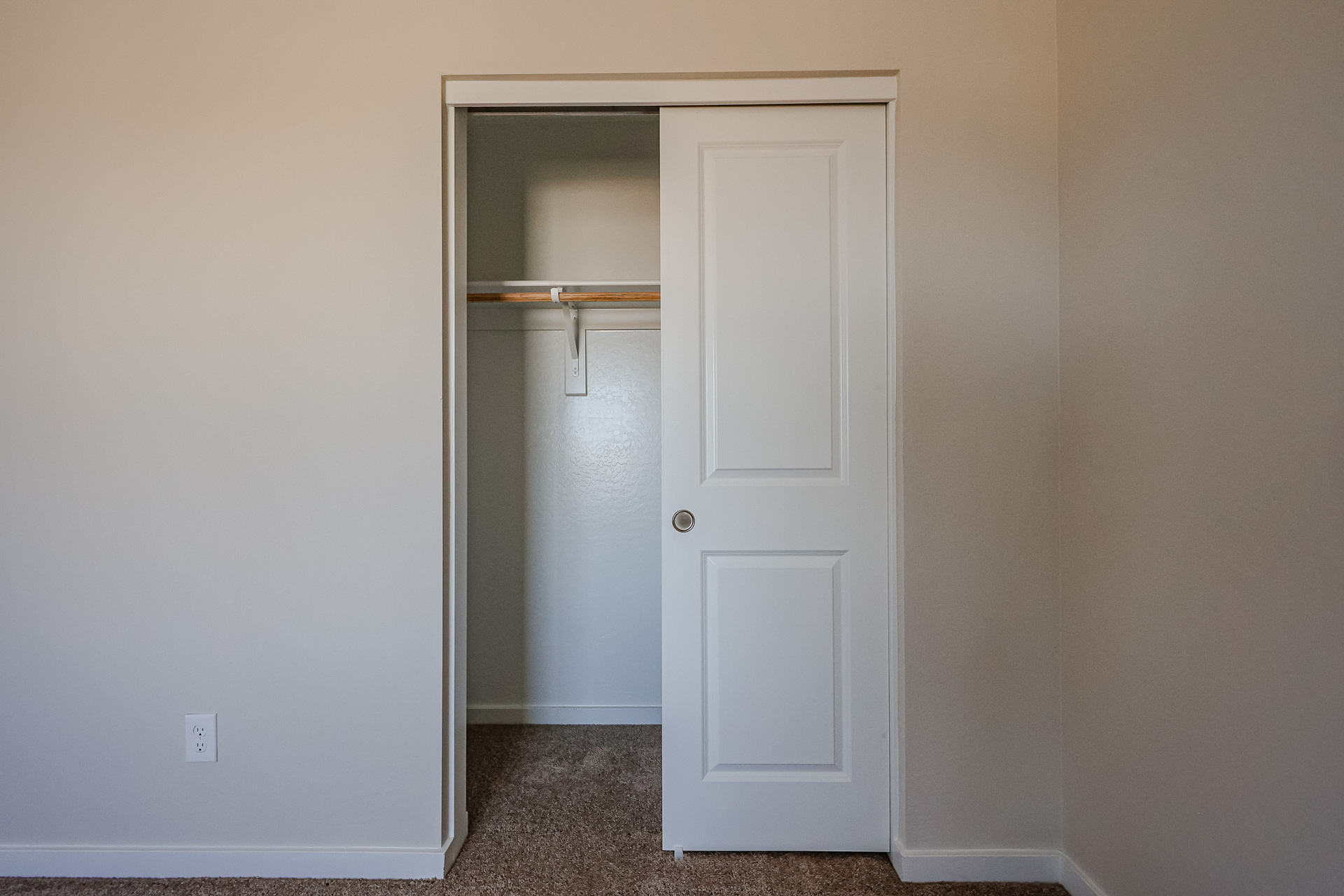 A white door with a metal bar.