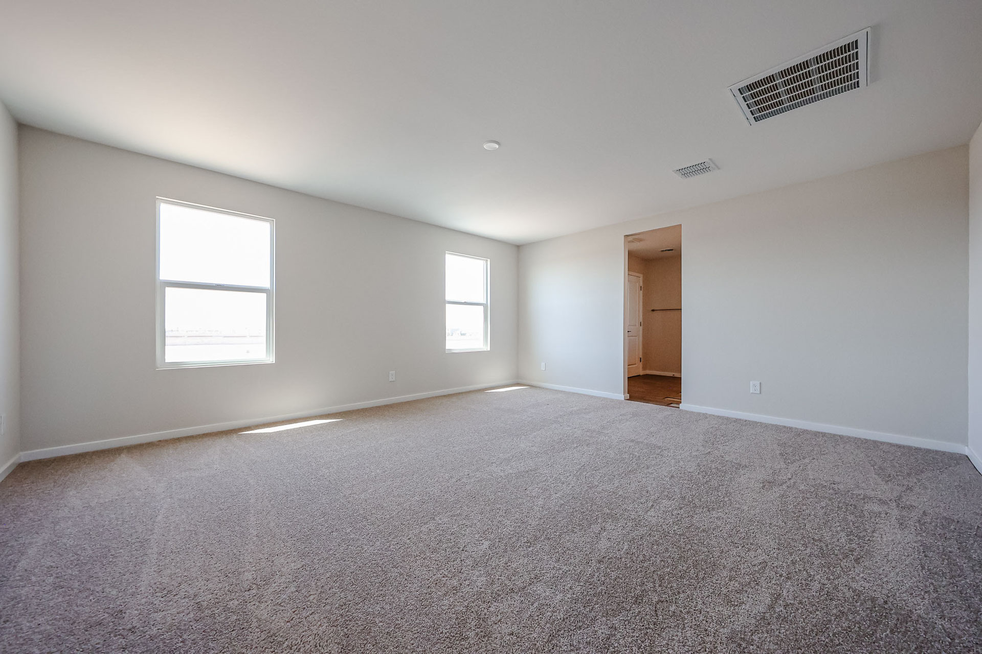 A room with a carpet and a door.