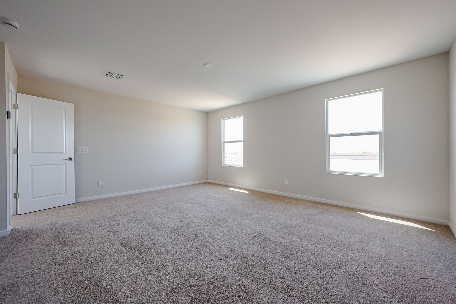 A room with a carpet and windows.