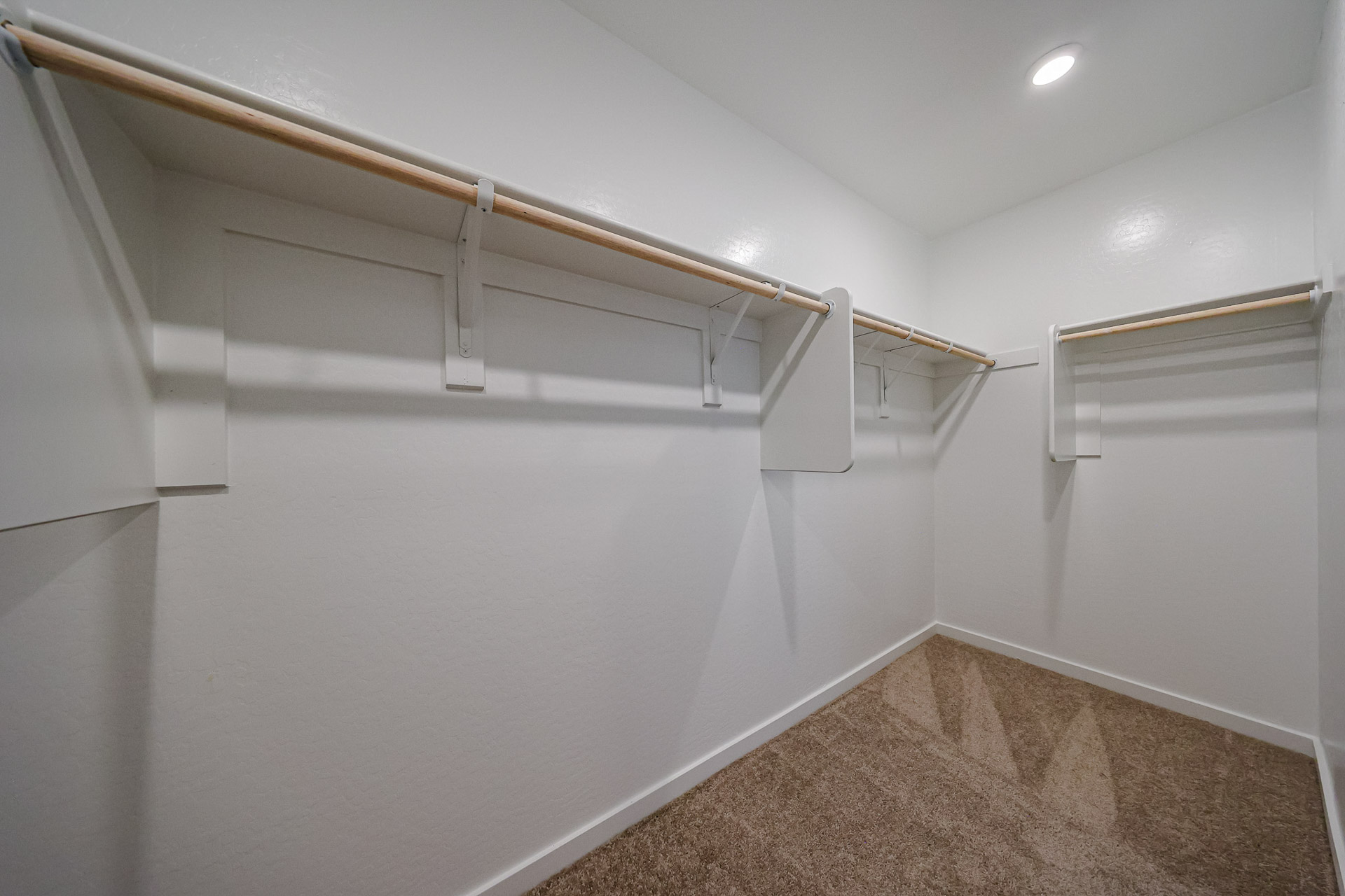 A white wall with a metal bar.
