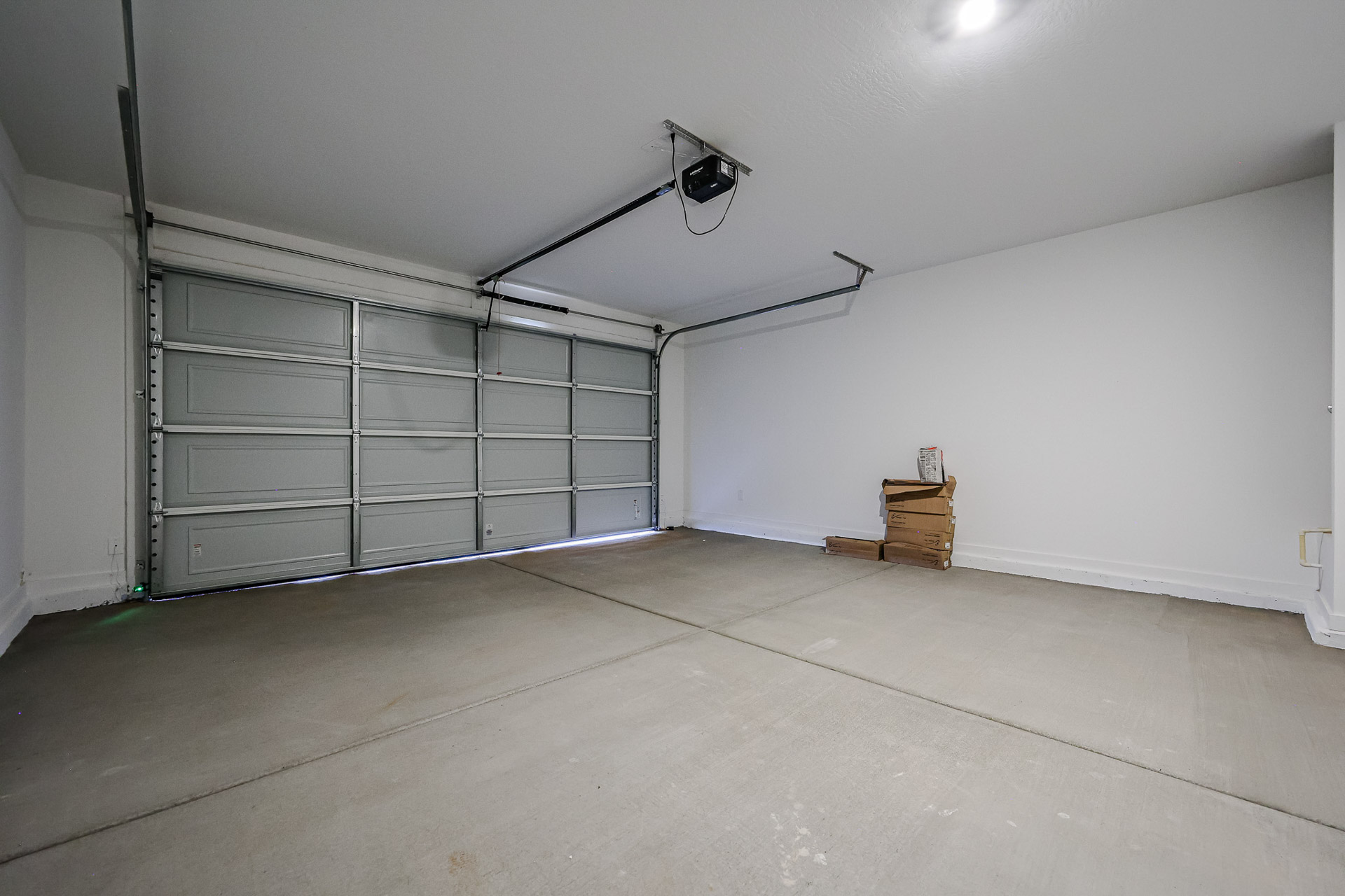 A room with a metal door and a light on the wall.
