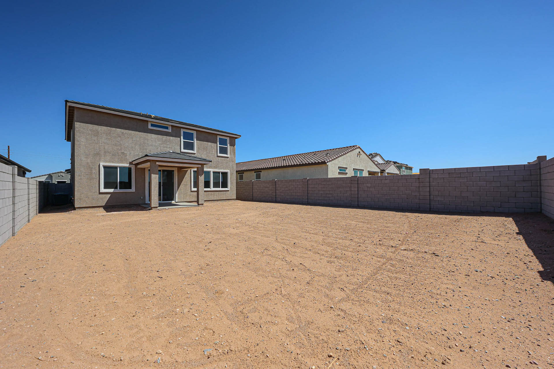 A dirt field with buildings in the background.