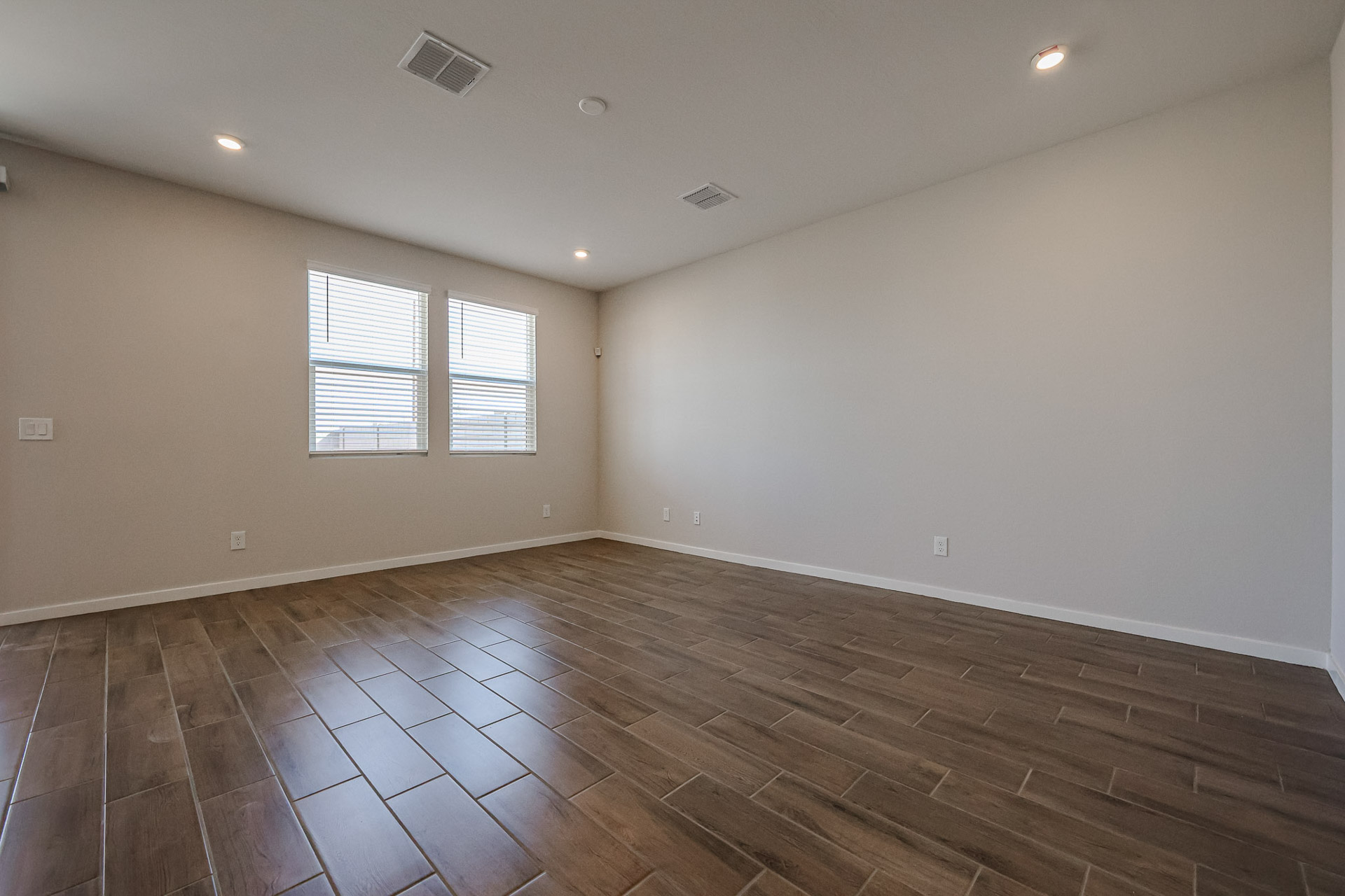 A room with a wood floor and windows.