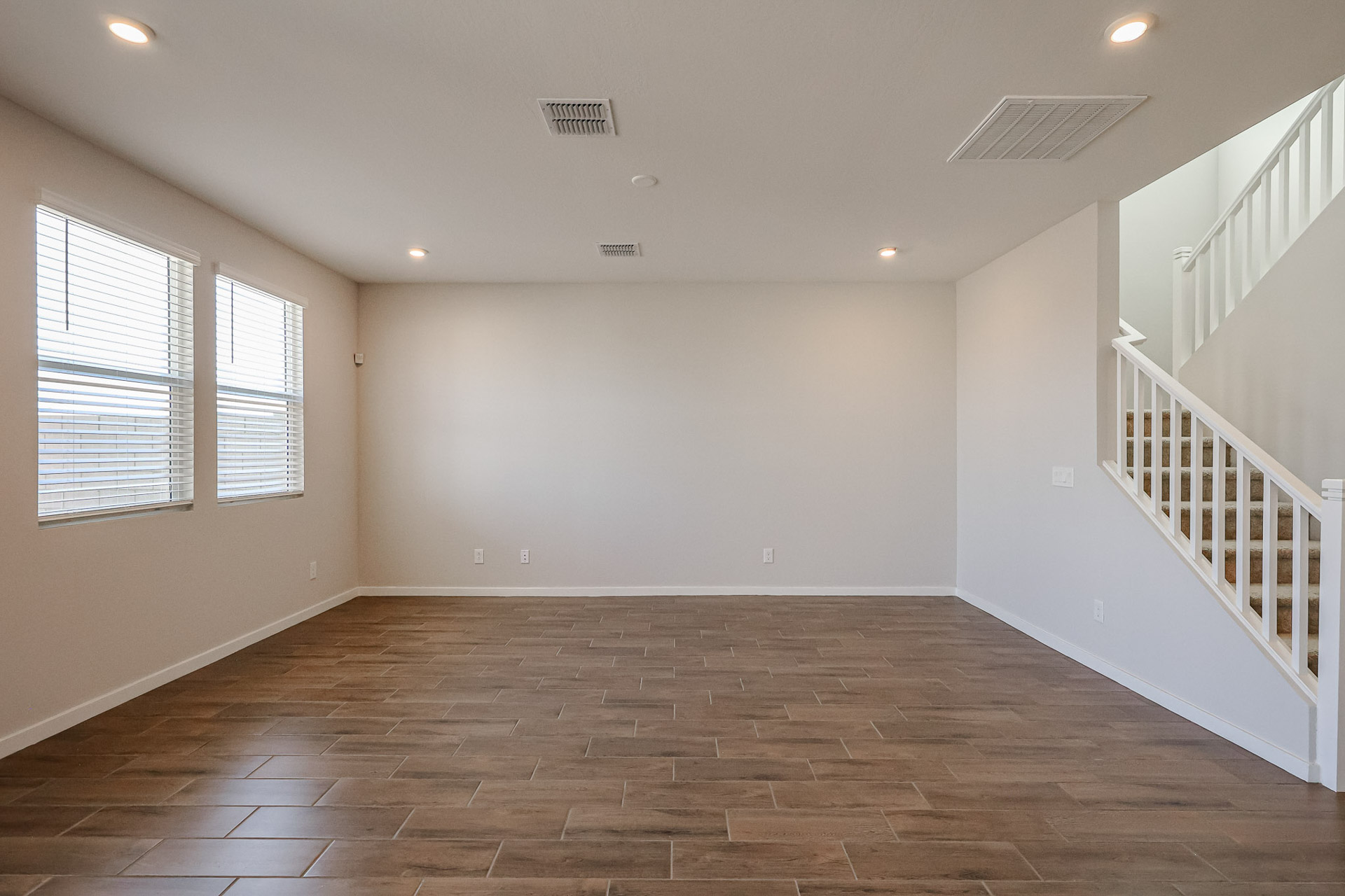 A room with a staircase and windows.